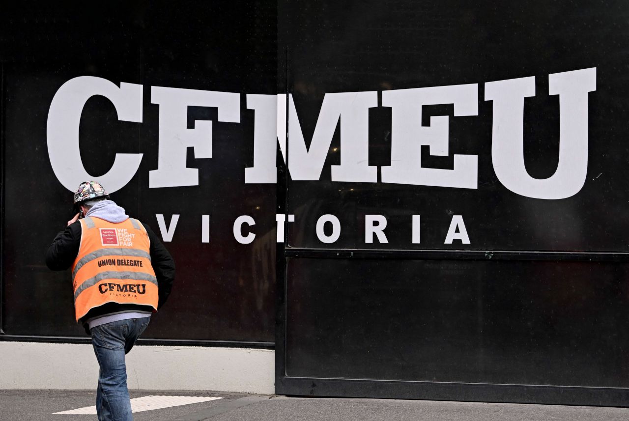A trade unionist walks past a CMFEU banner
