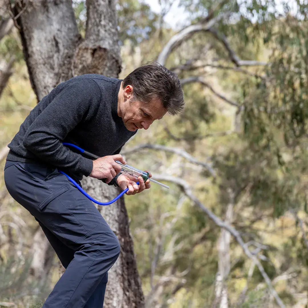 A man outdoors with a tube device