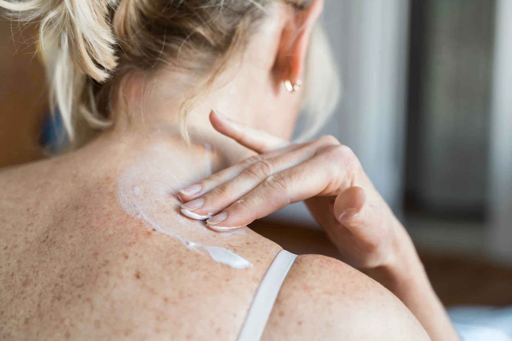 A women applying oestrogen gel to her shoulder