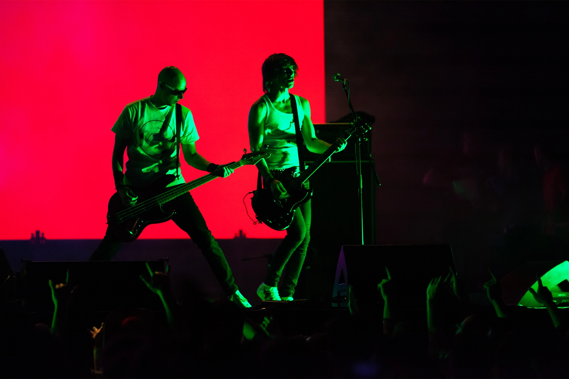 Two guitarists on a dark stage