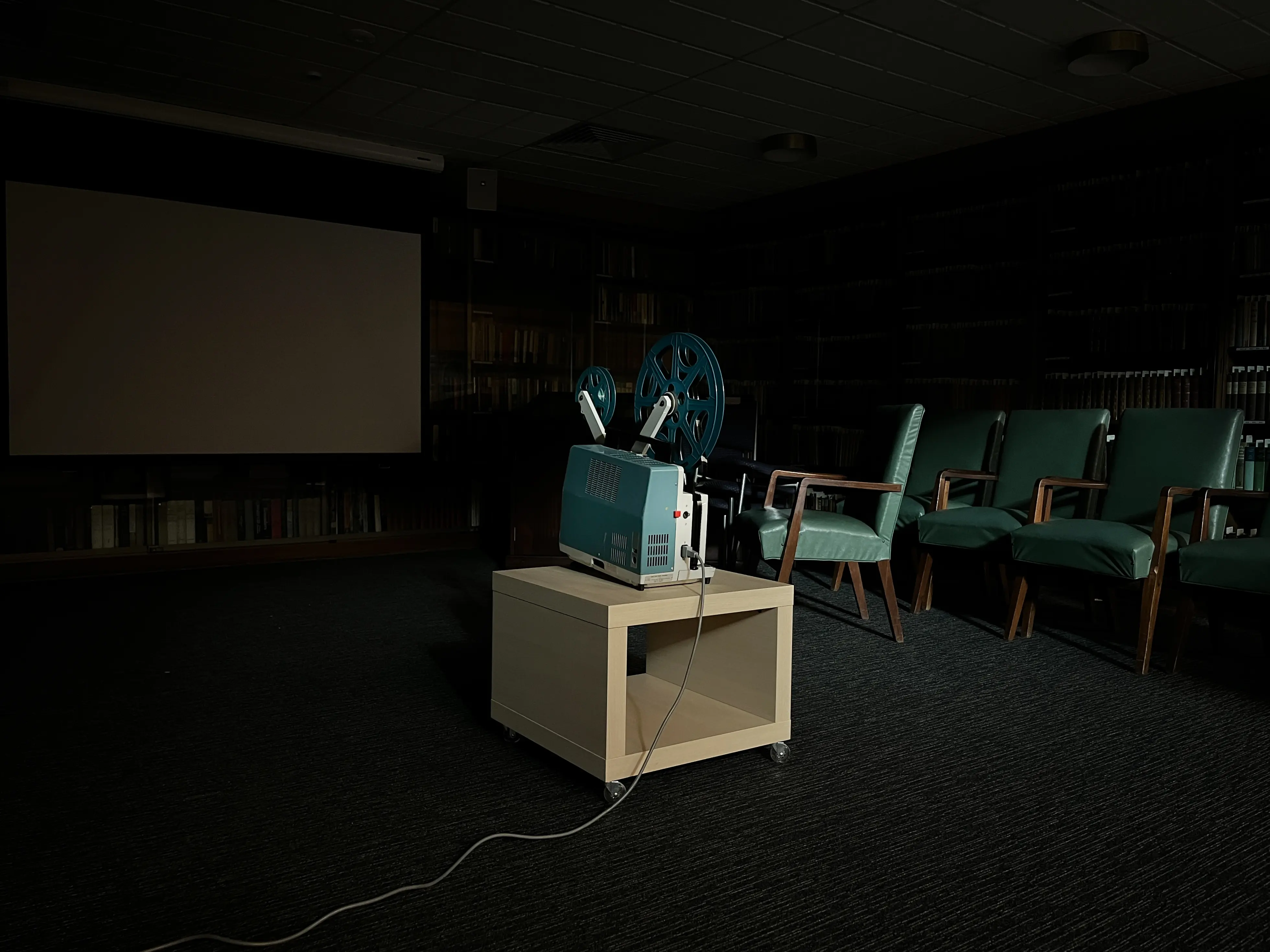 A film projector sitting in the middle of a dark room.