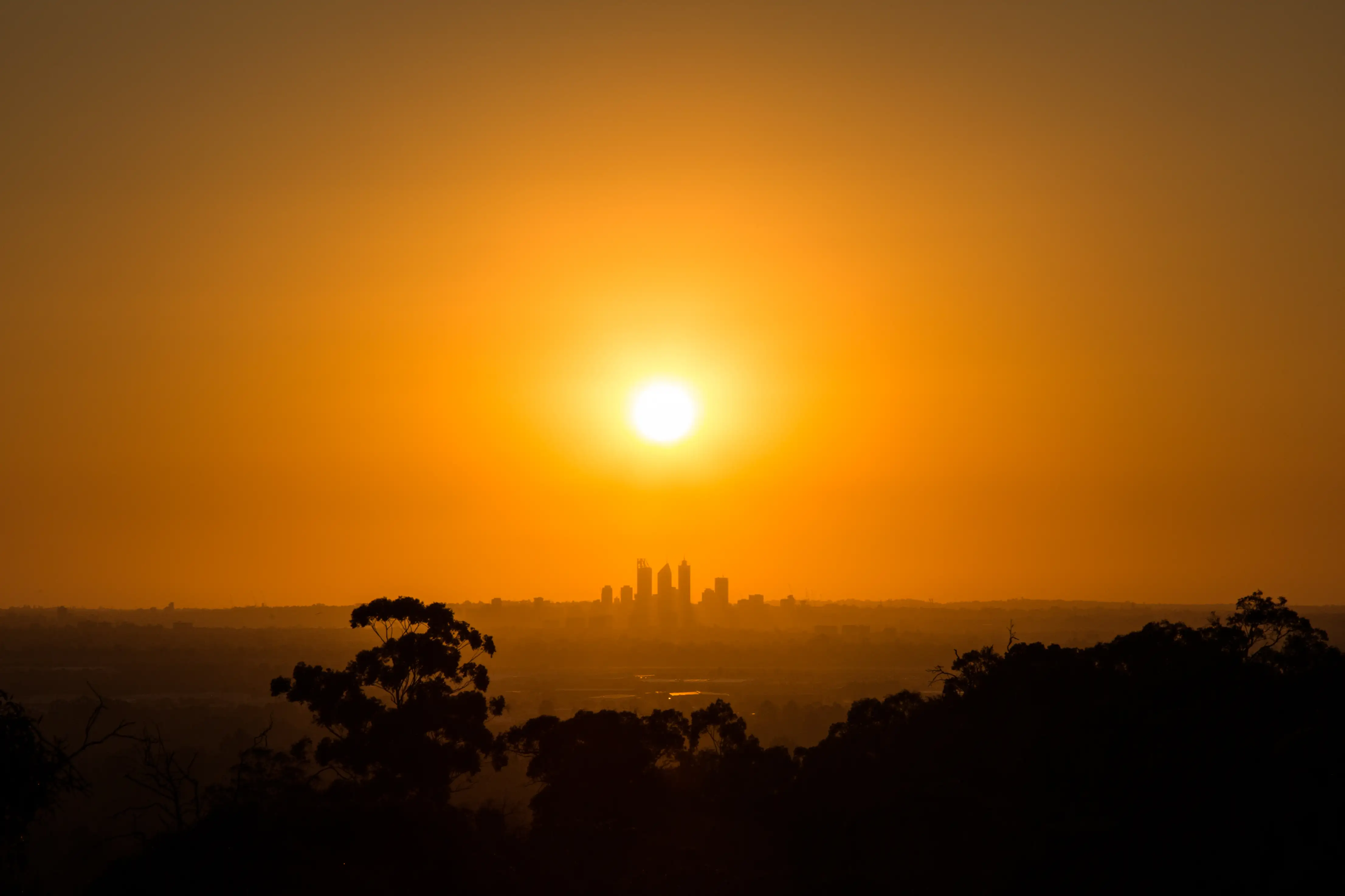 Perth skies glow orange in a heatwave with the city in the distance.