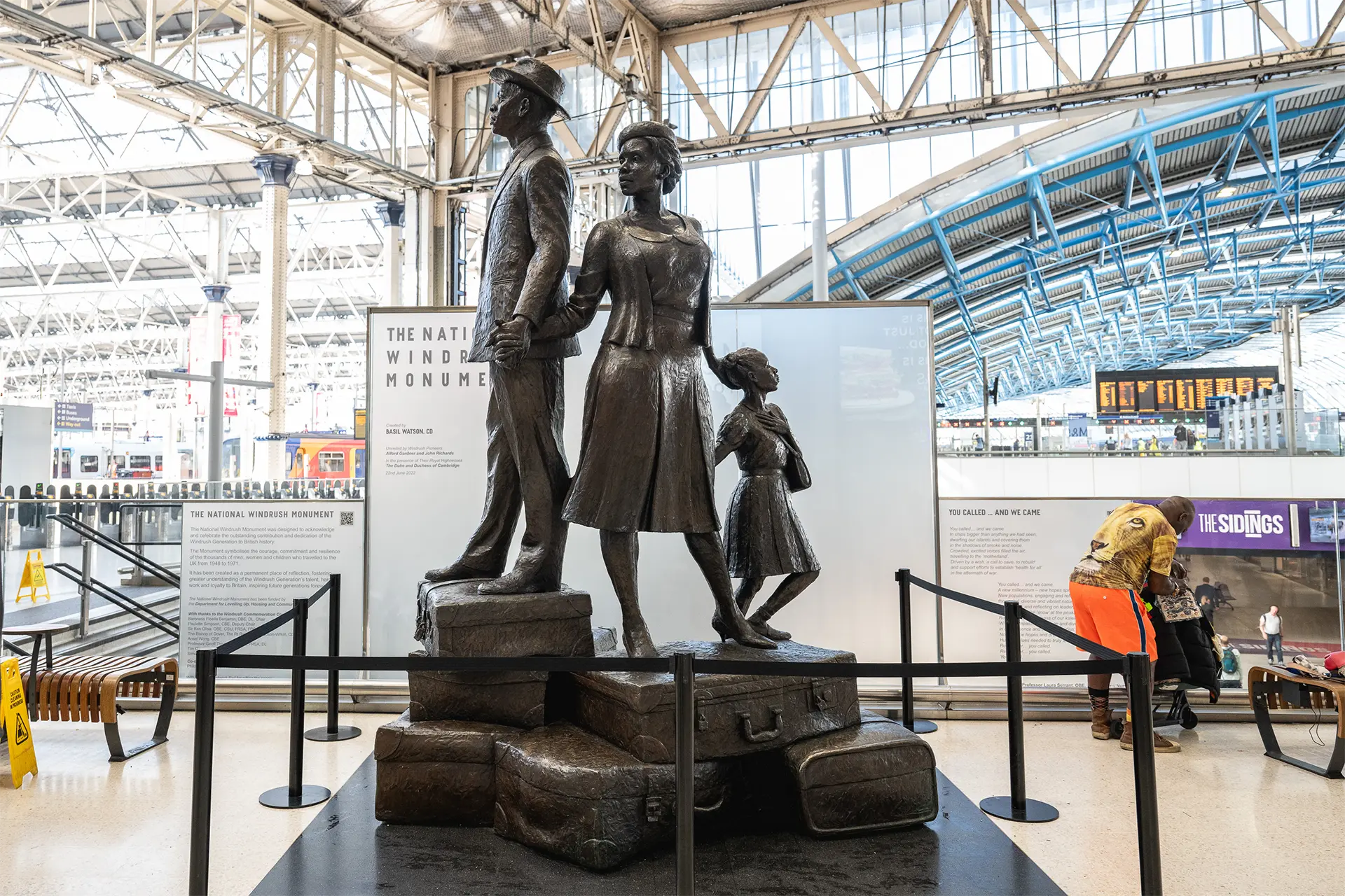 Statue of a family standing on luggage at a large train station