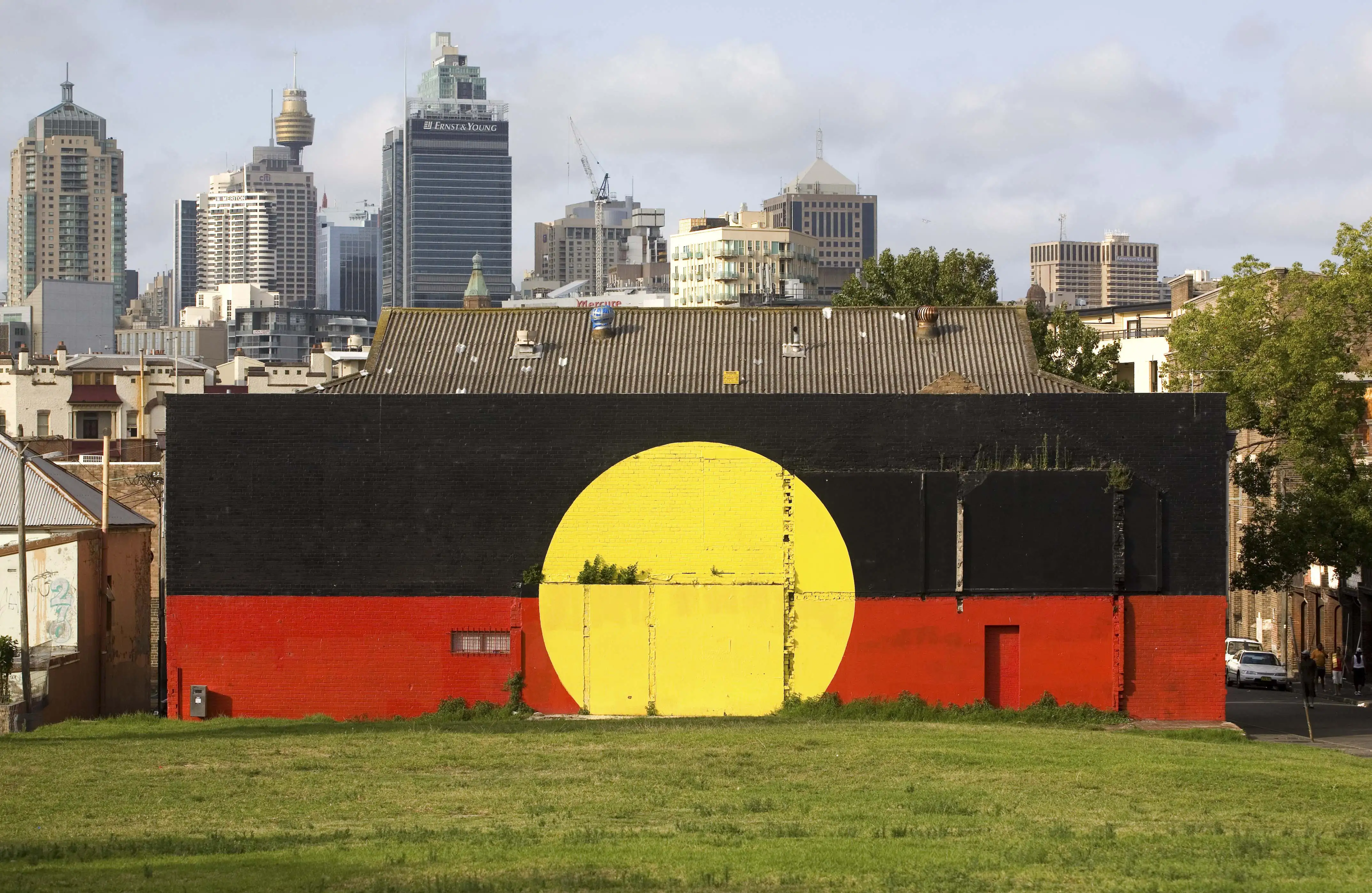 An Aboriginal flag mural in front of the Sydney skyline in Redfern in 2008.