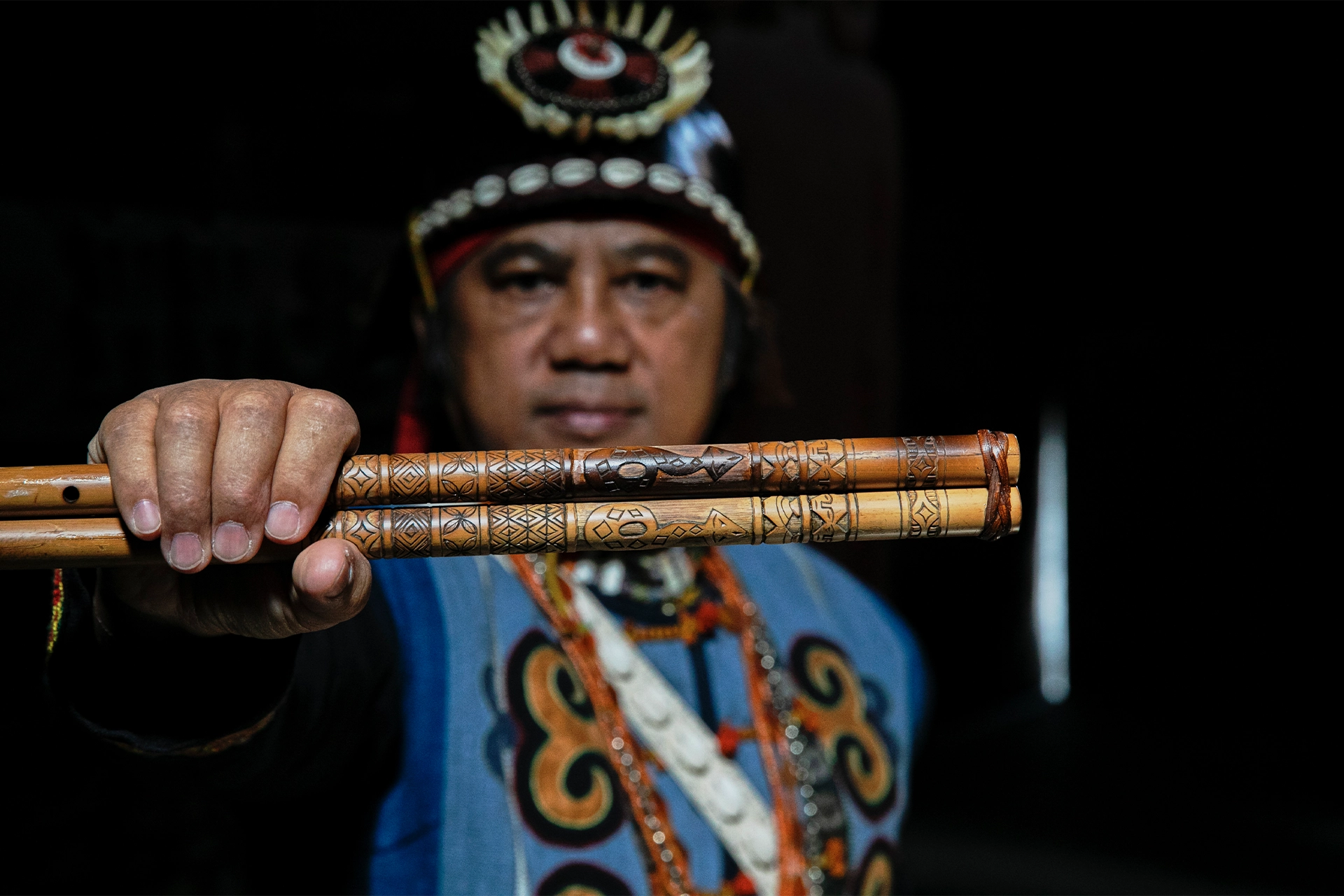 Man in traditional Paiwan clothes holding a flute