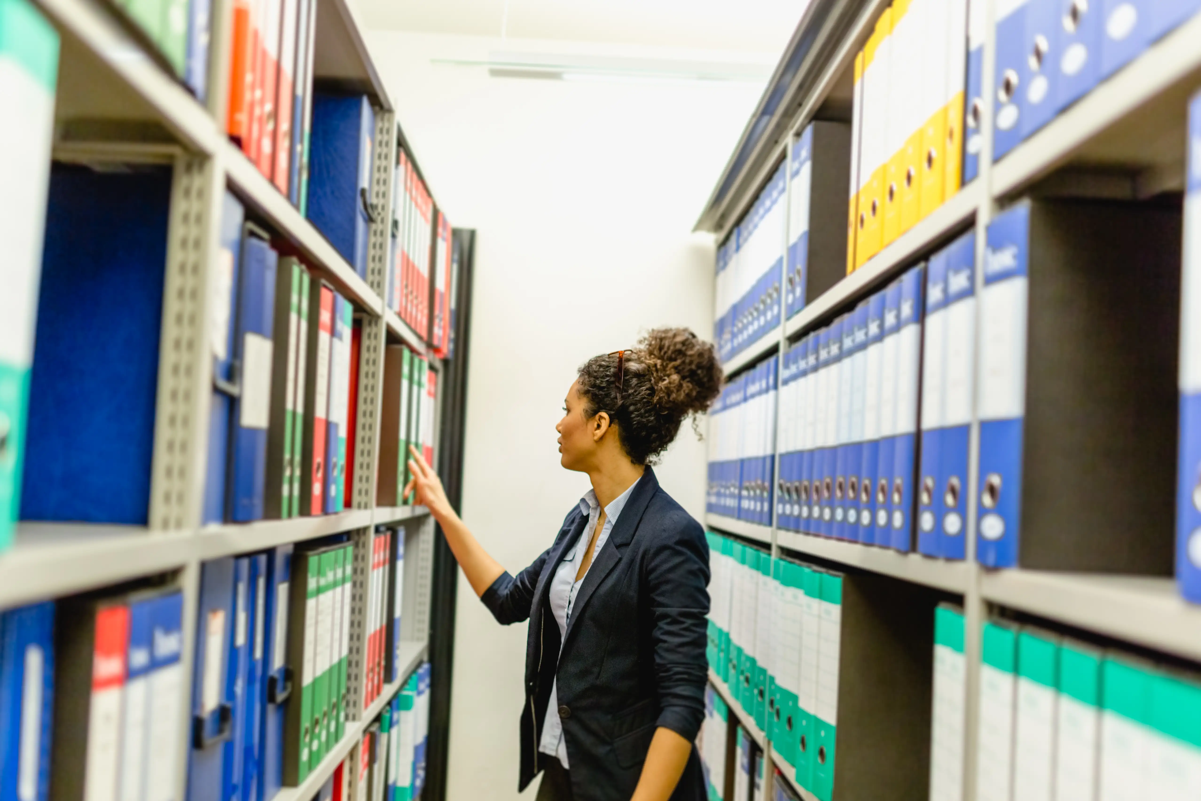 A woman checks files in an office