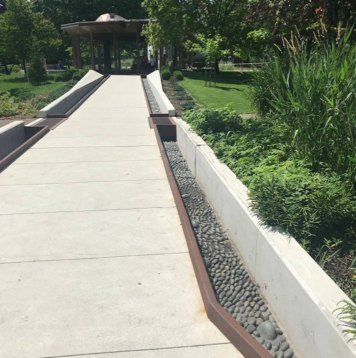 A concrete pedestrian bridge and garden