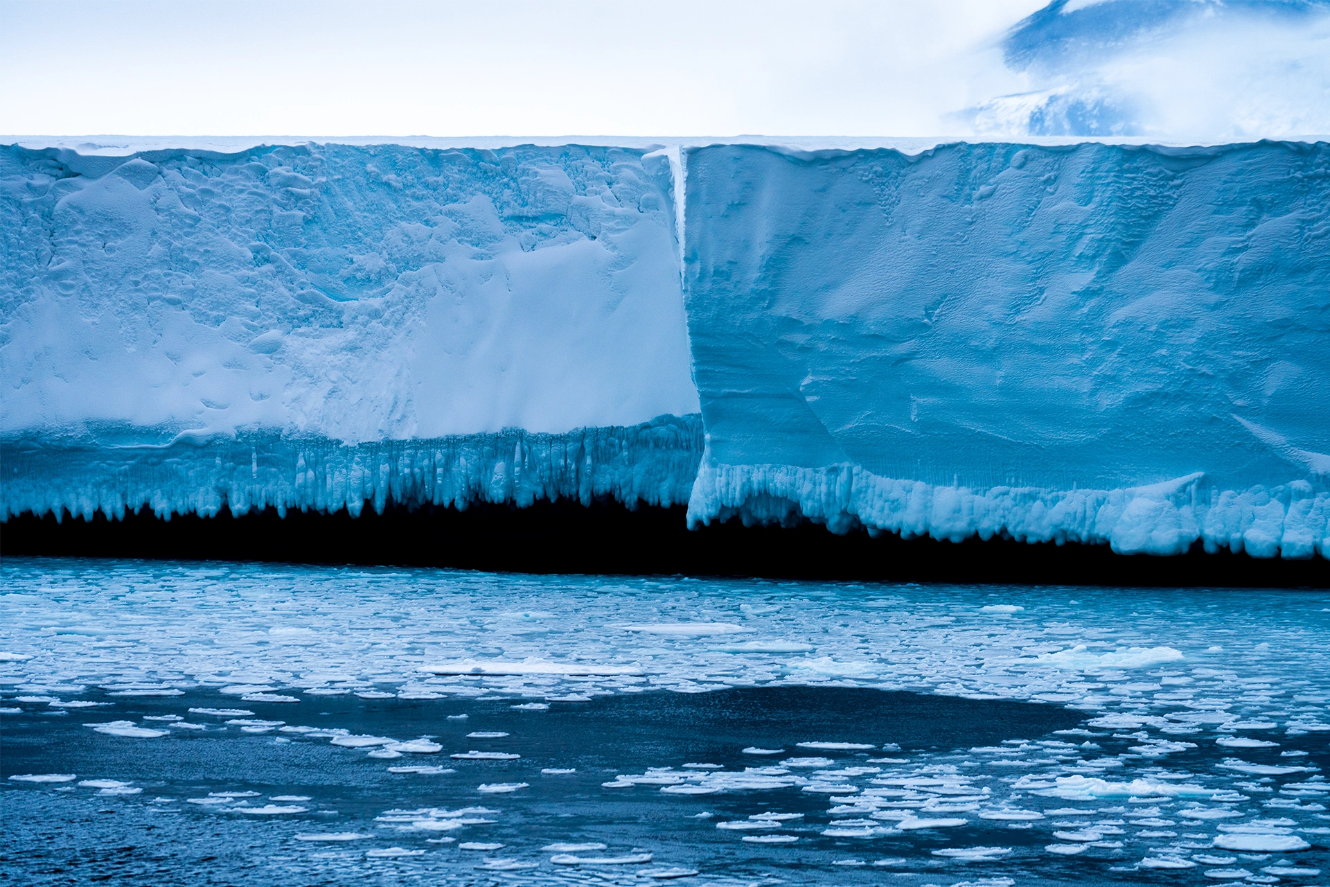 Large Antarctic ice shelf with ocean in foreground