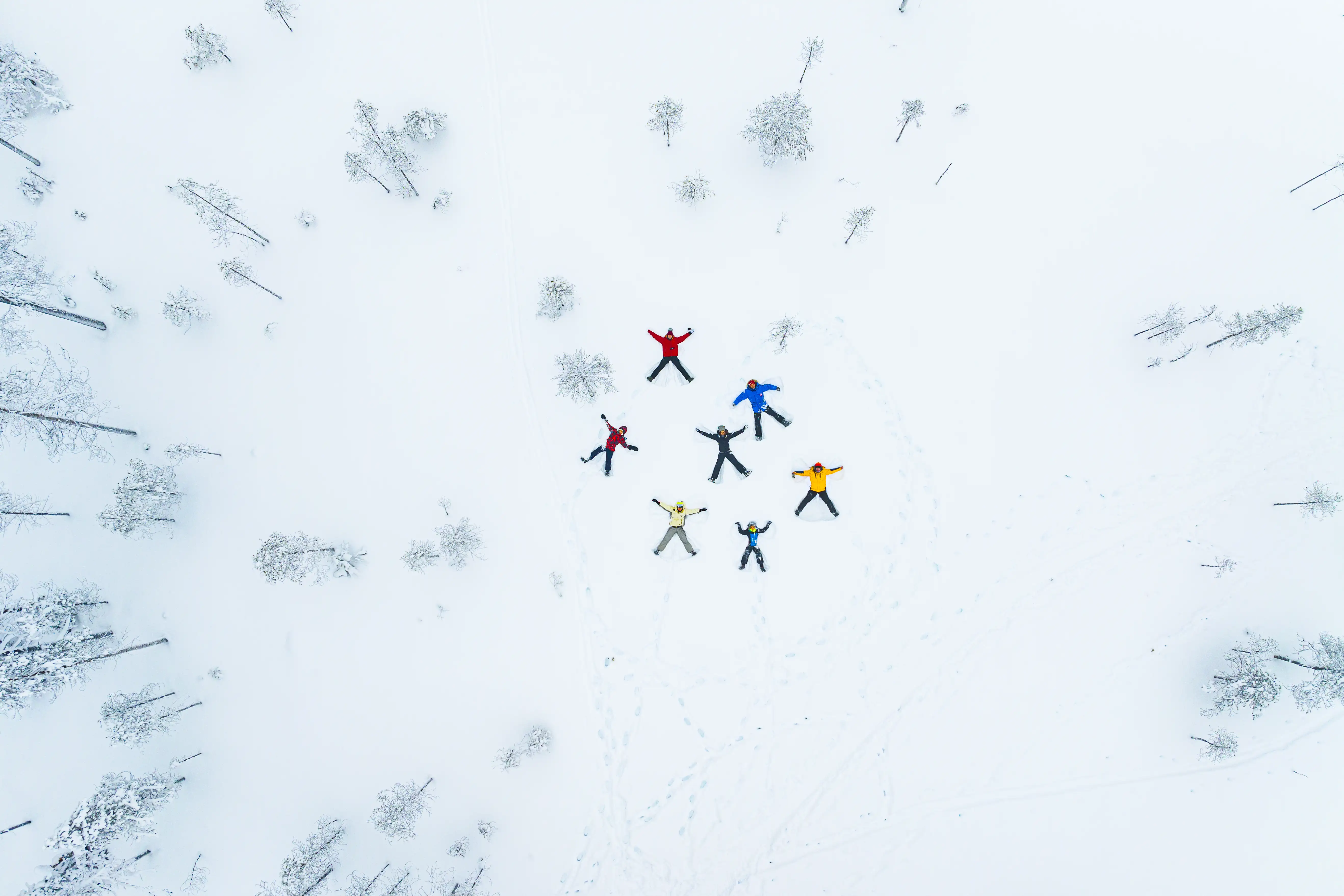 A family making 'snow angels' in Finland