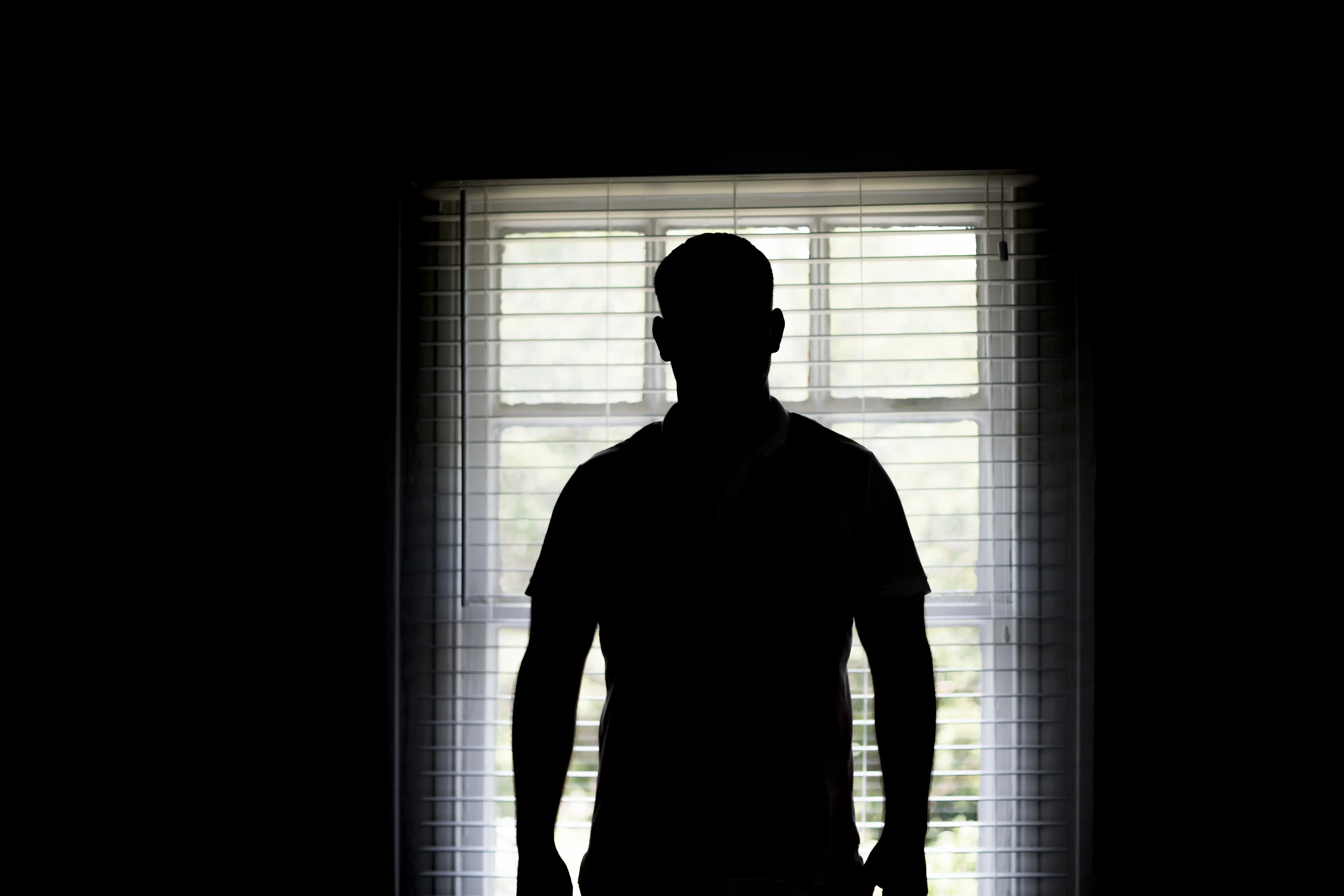 A silhouette of a man in a doorway