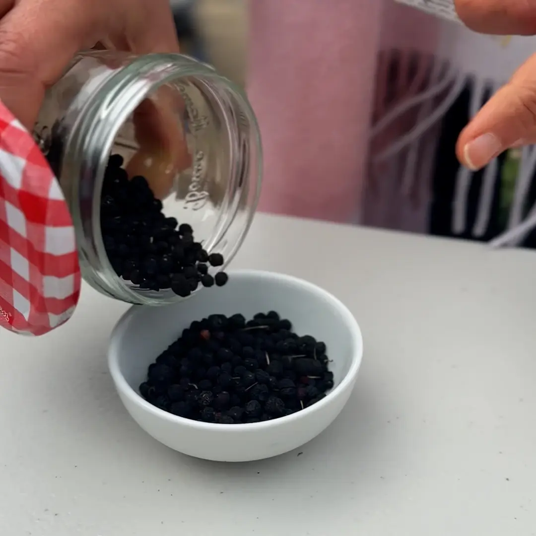 Berries being tipped out of a glass jar into a small bowl