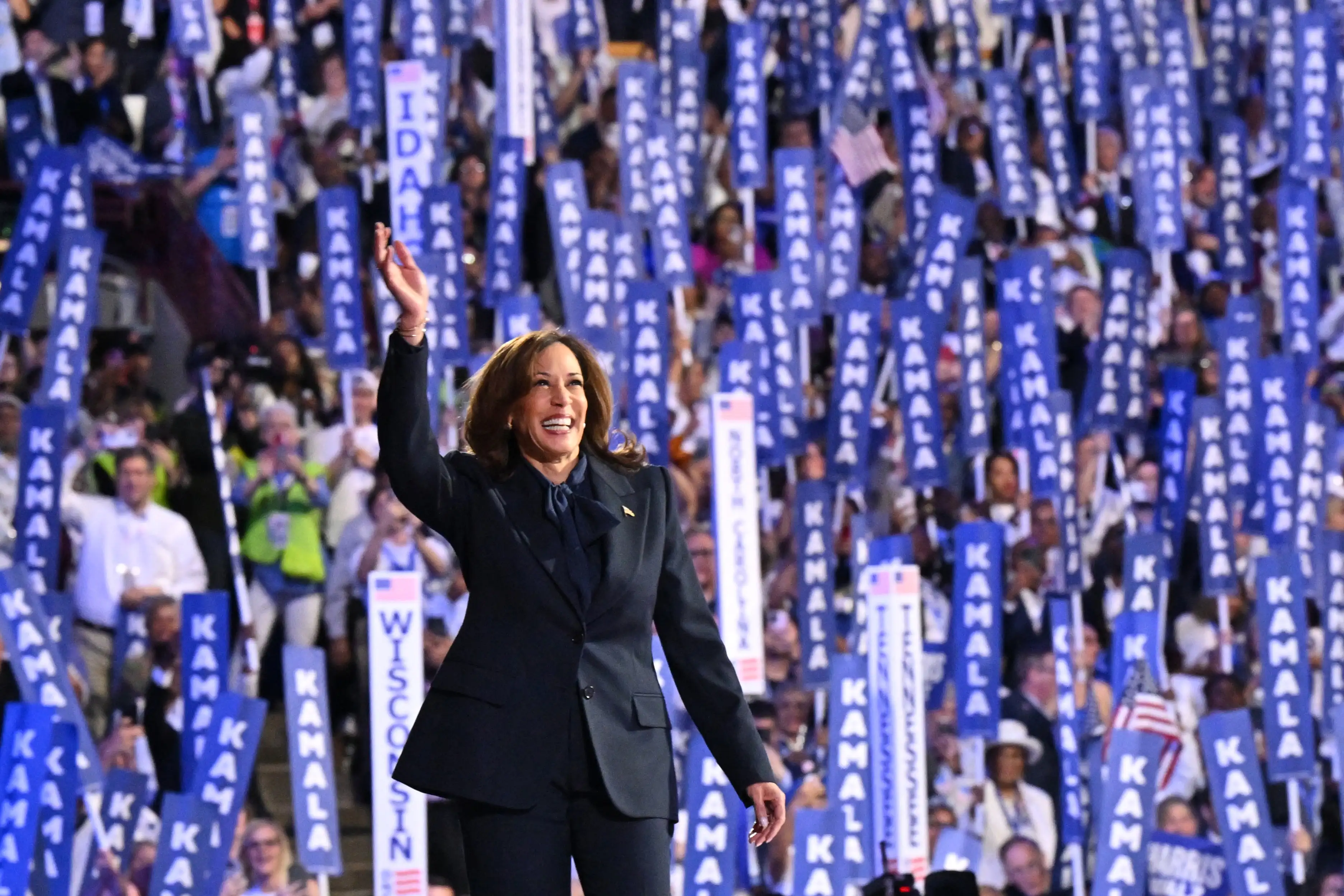 US Vice President and 2024 Democratic presidential candidate Kamala Harris waves as she arrives to speak on the fourth and last day of the Democratic National Convention