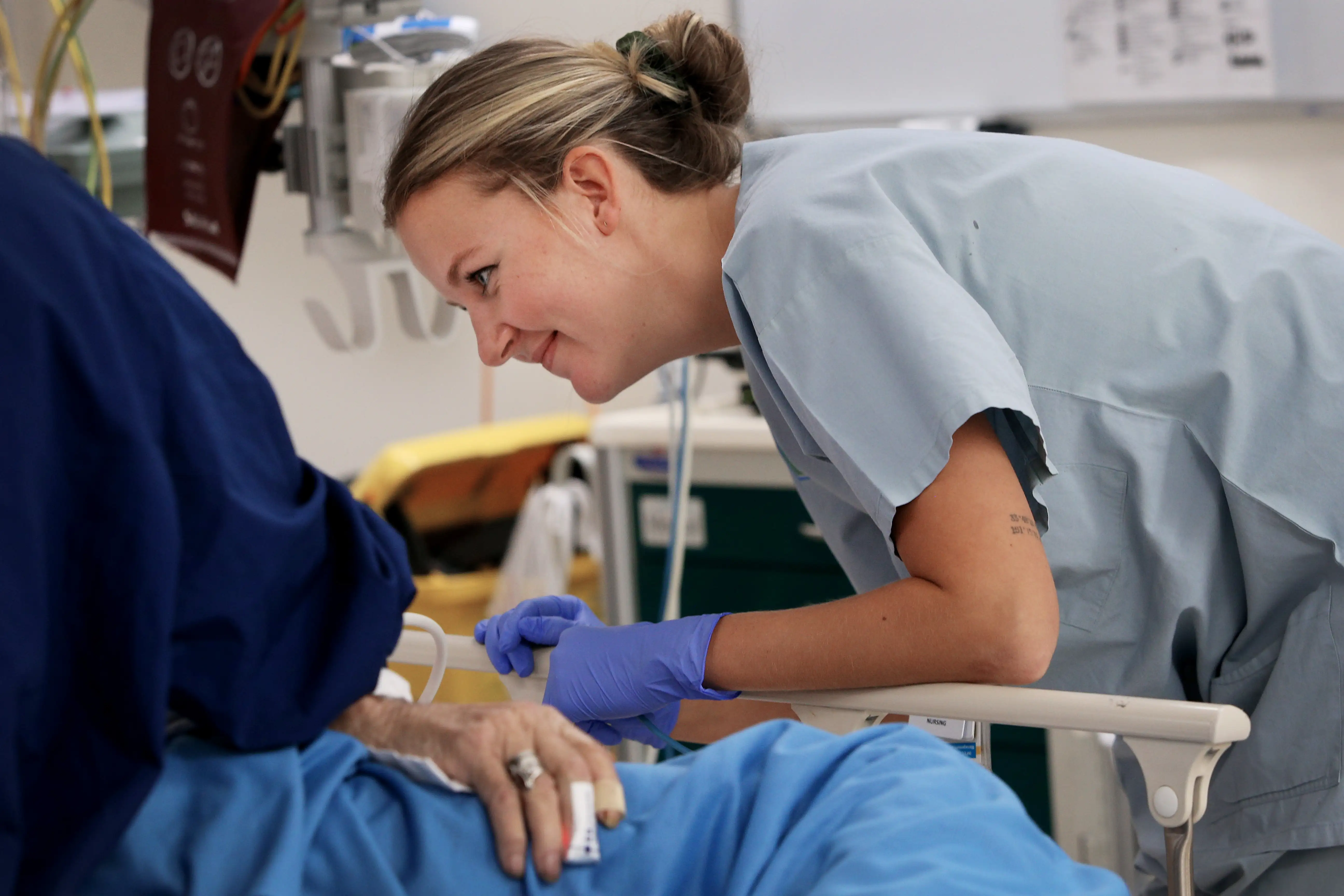 A nurse talks to an elderly patient in hospital