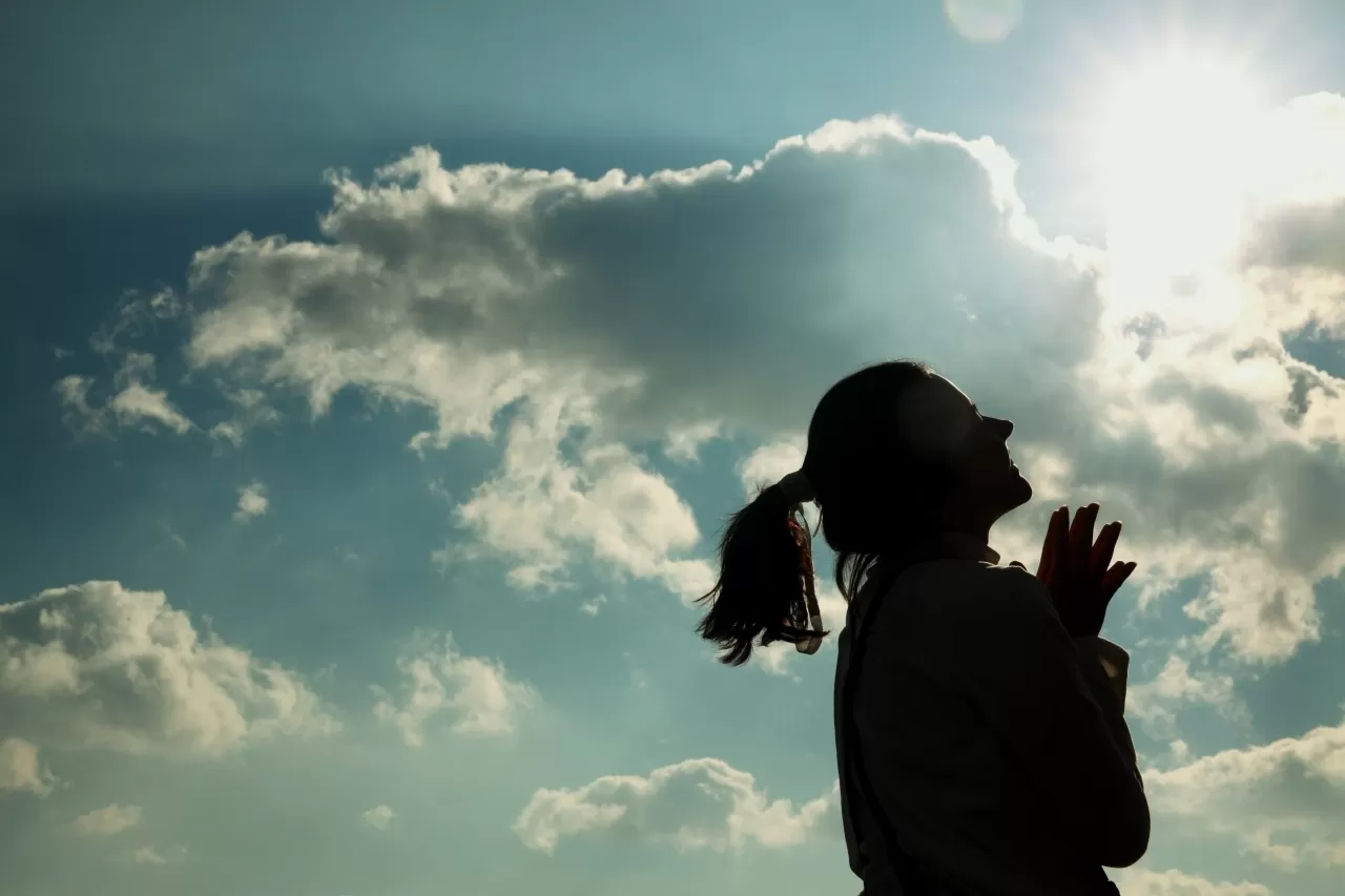 Young woman smiling against a blue sky