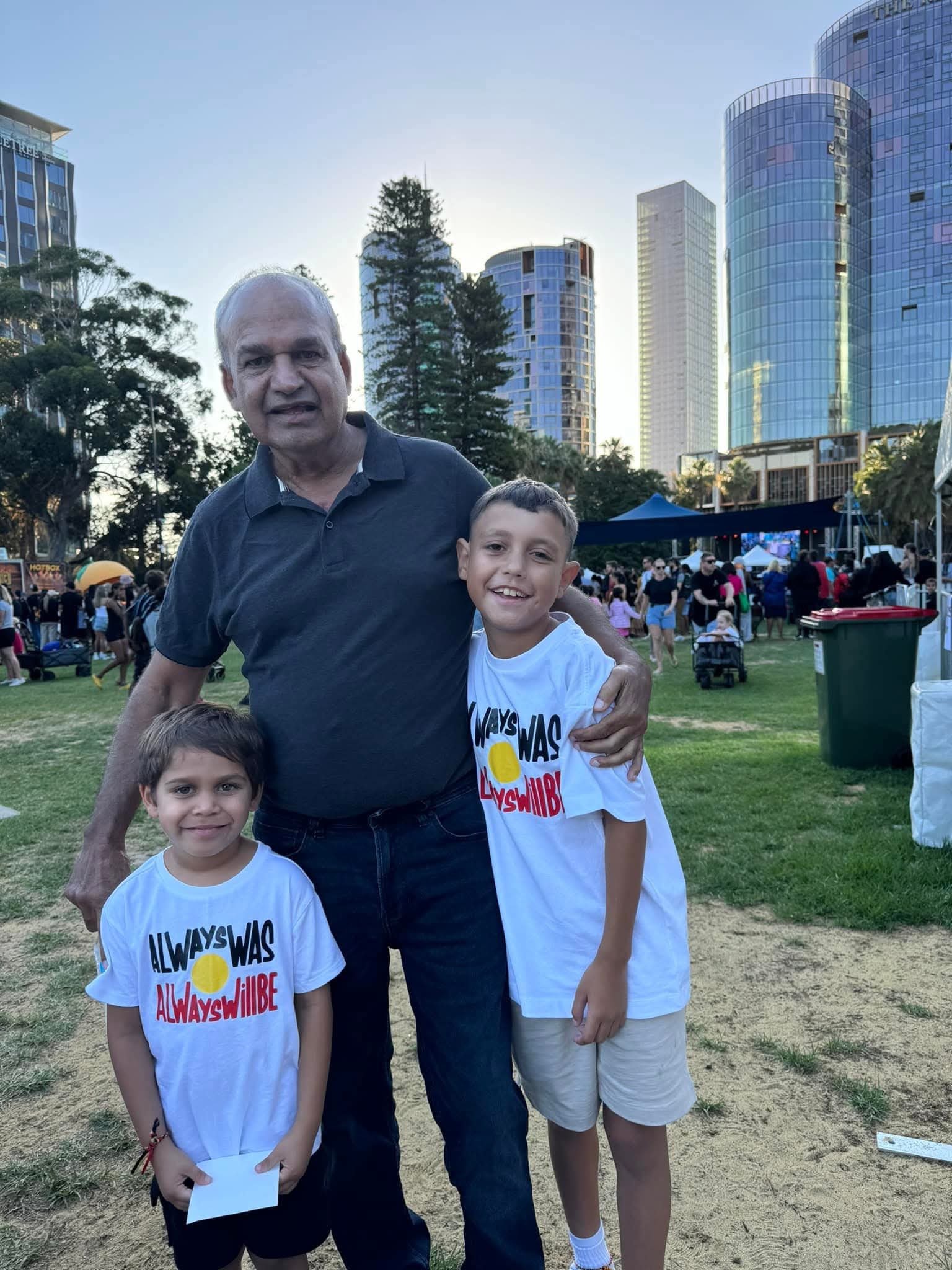 Man and two boys standing in a park
