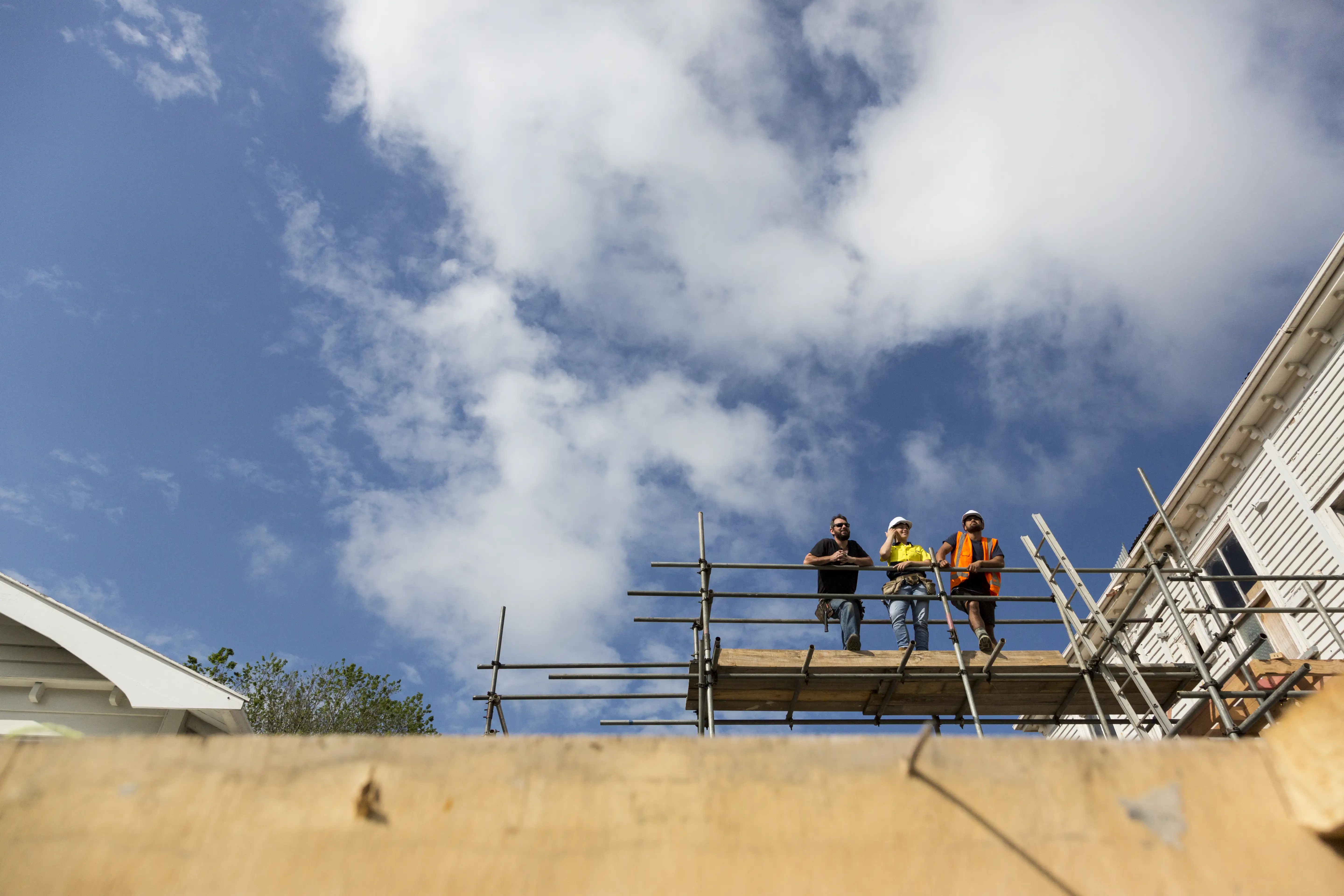 Three buildings on scaffolding near the construction of a residential building