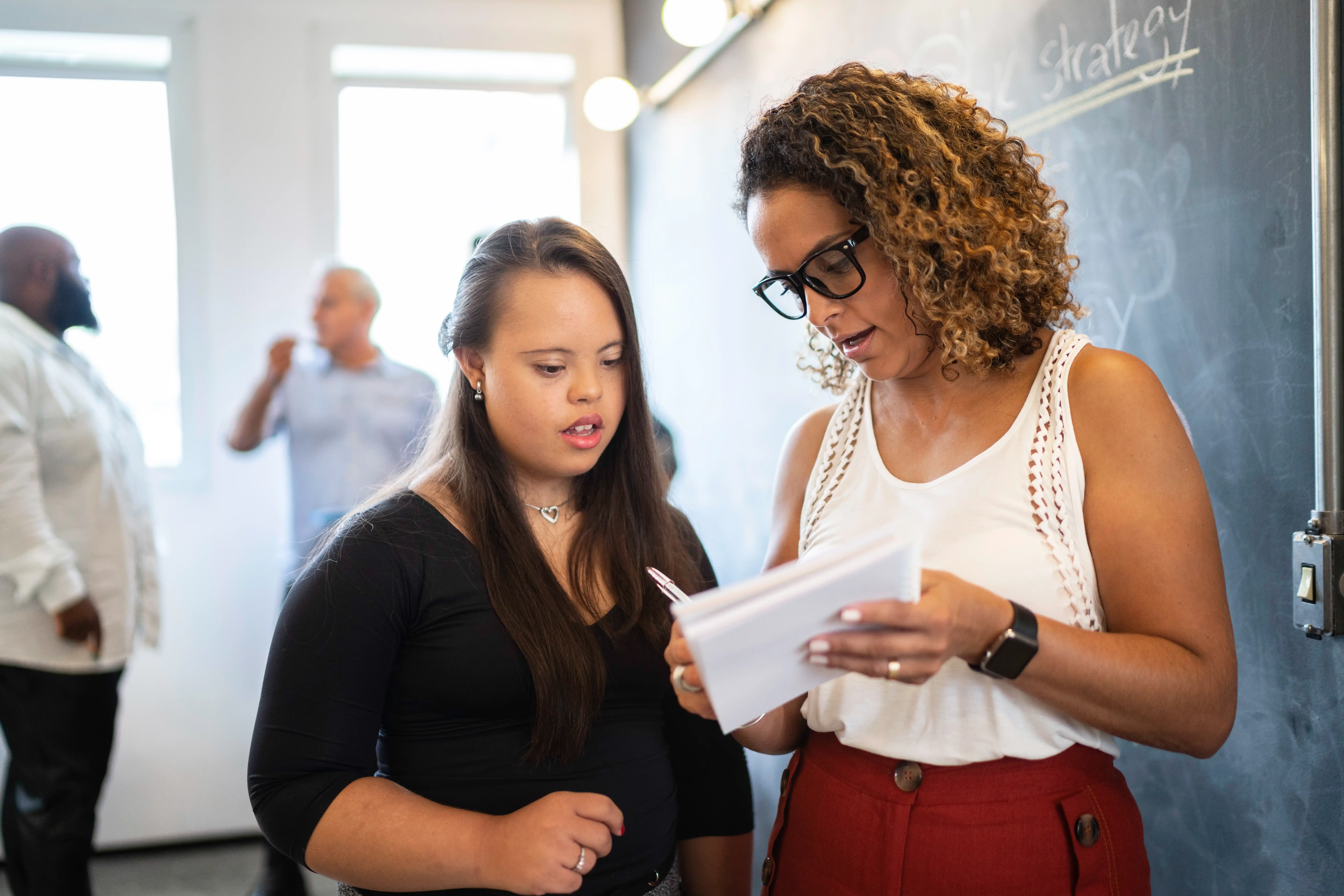 A woman living with an intellectual disability talking to her female boss at work