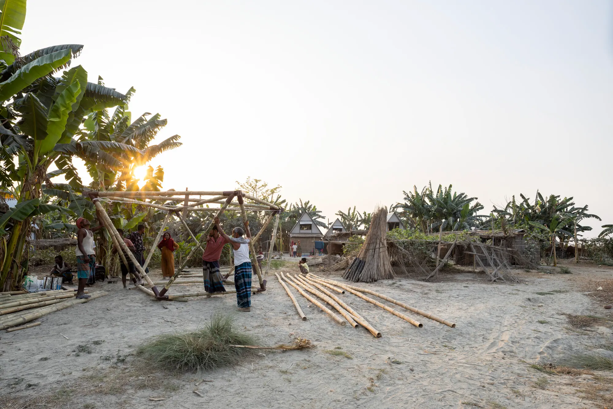 A group of people constructing the base of a bamboo movable house in Bangladesh