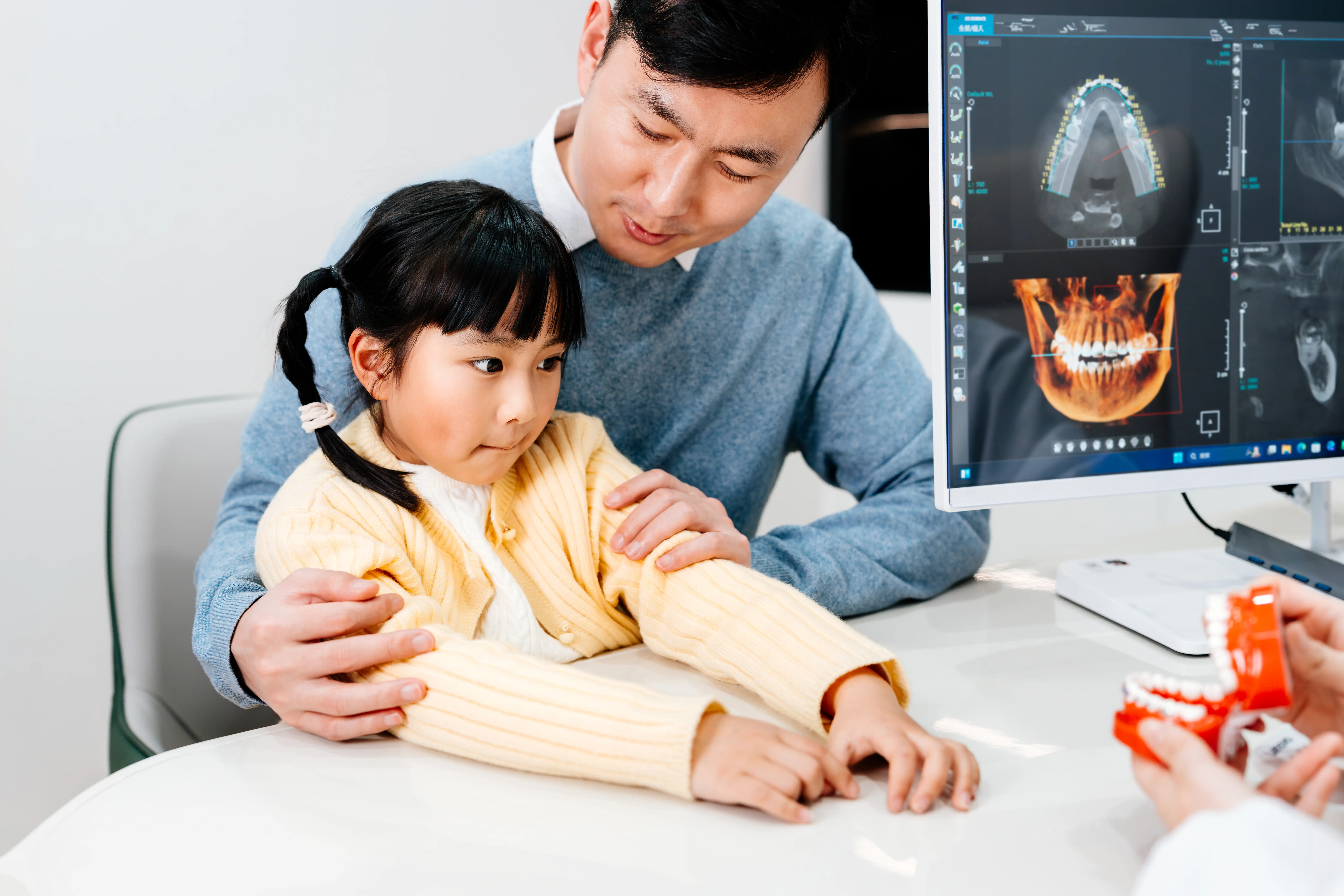 A father and daughter chatting to a dentist in her office