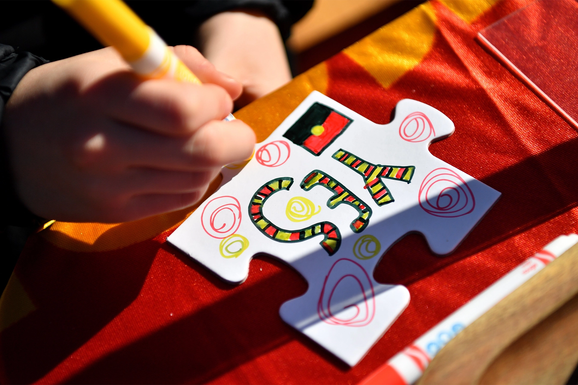 A child decorating a Yes puzzle piece