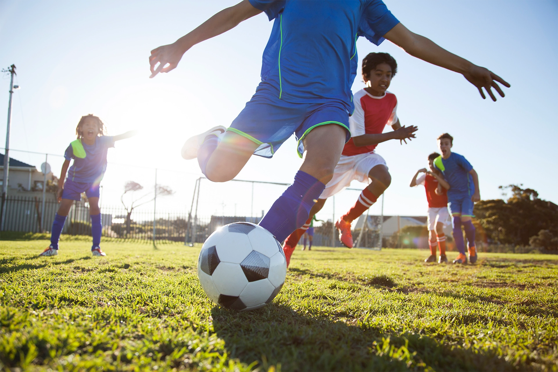 Boys playing soccer with ball in the foreground