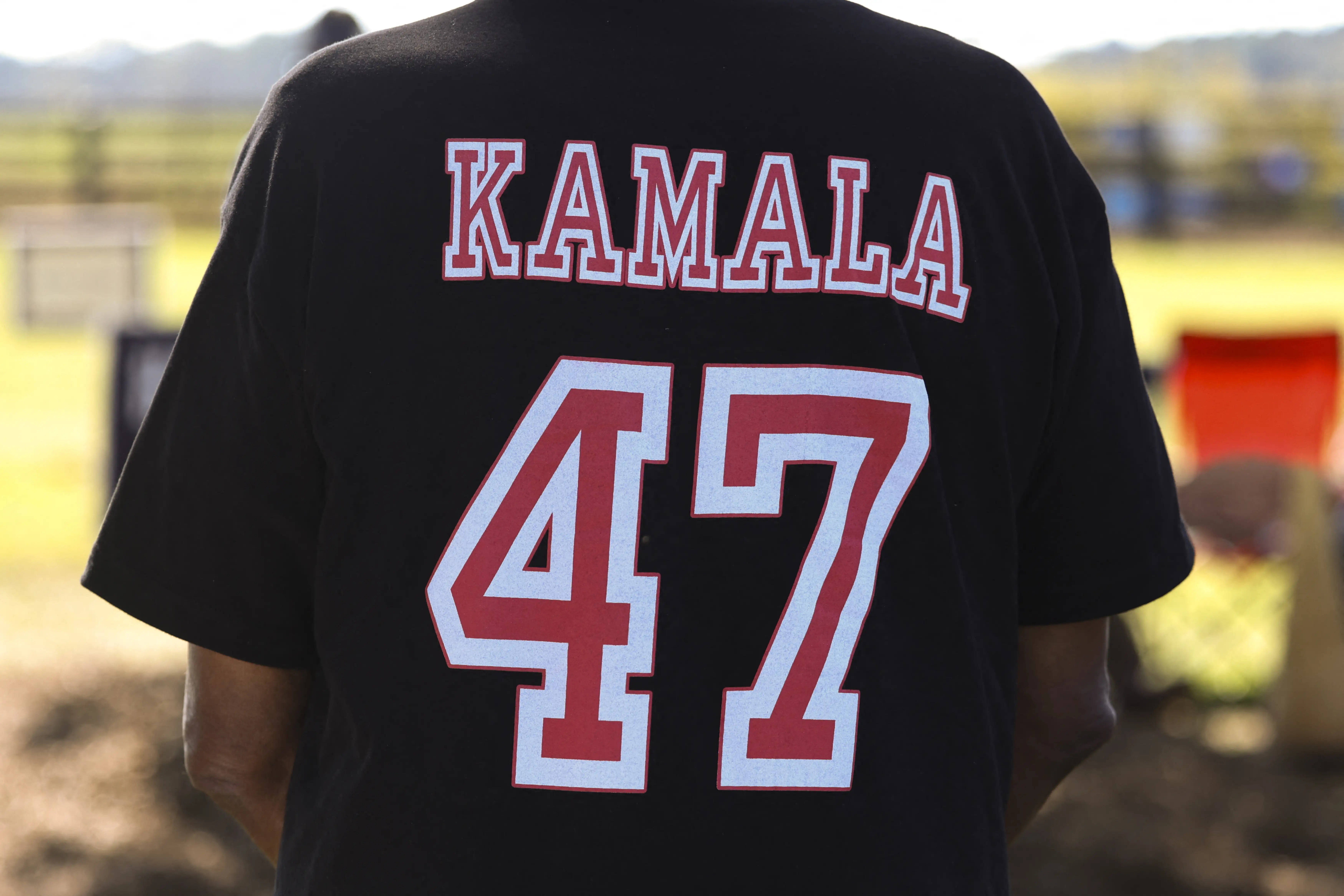 A campaigner wears a football jersey which reads 'Harris 47' on the back