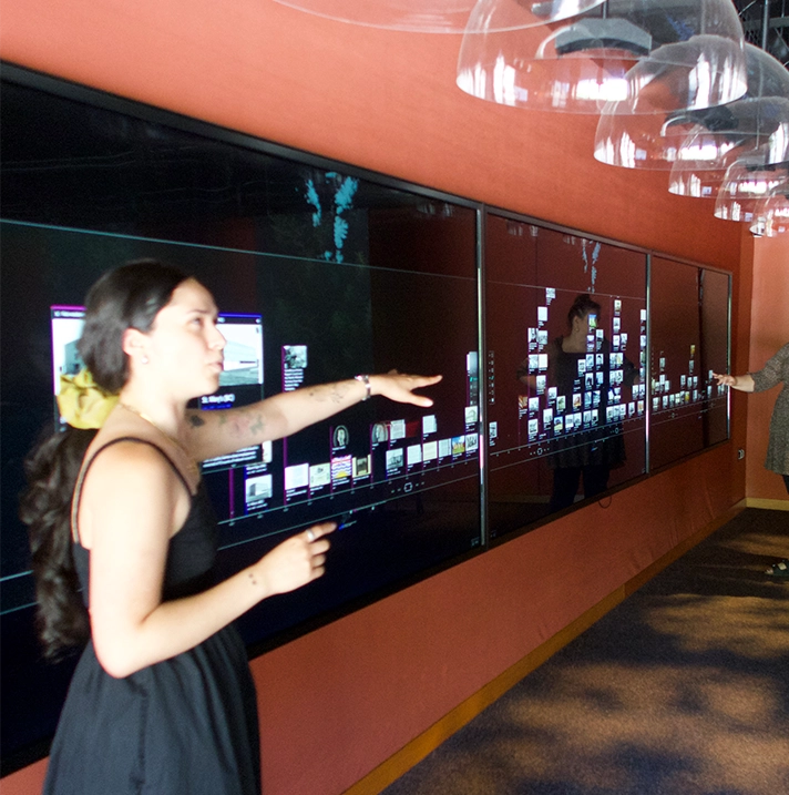 A woman pointing at a long digital screen