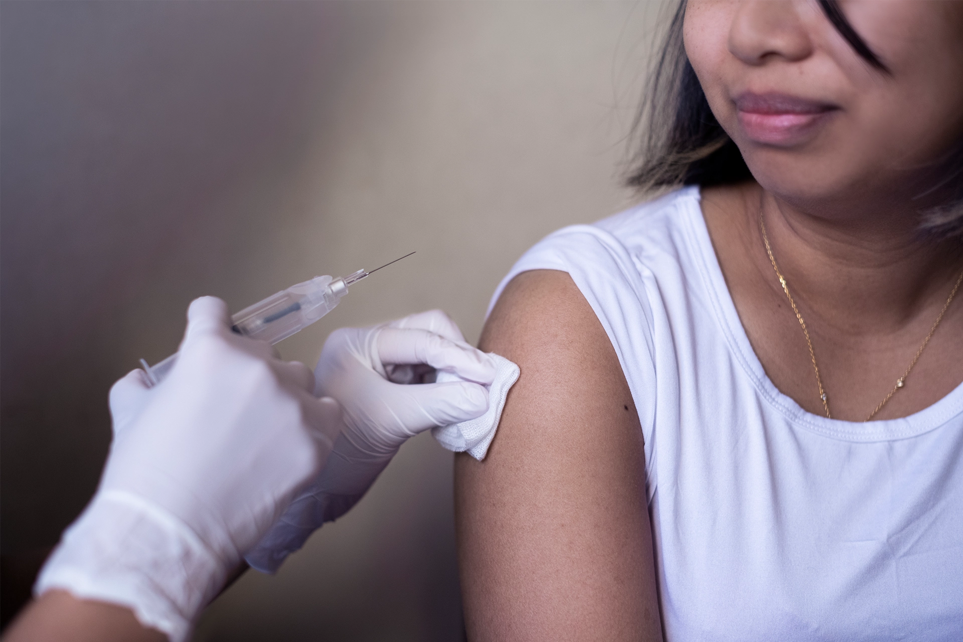 Close up of young woman receiving an injection in her upper arm