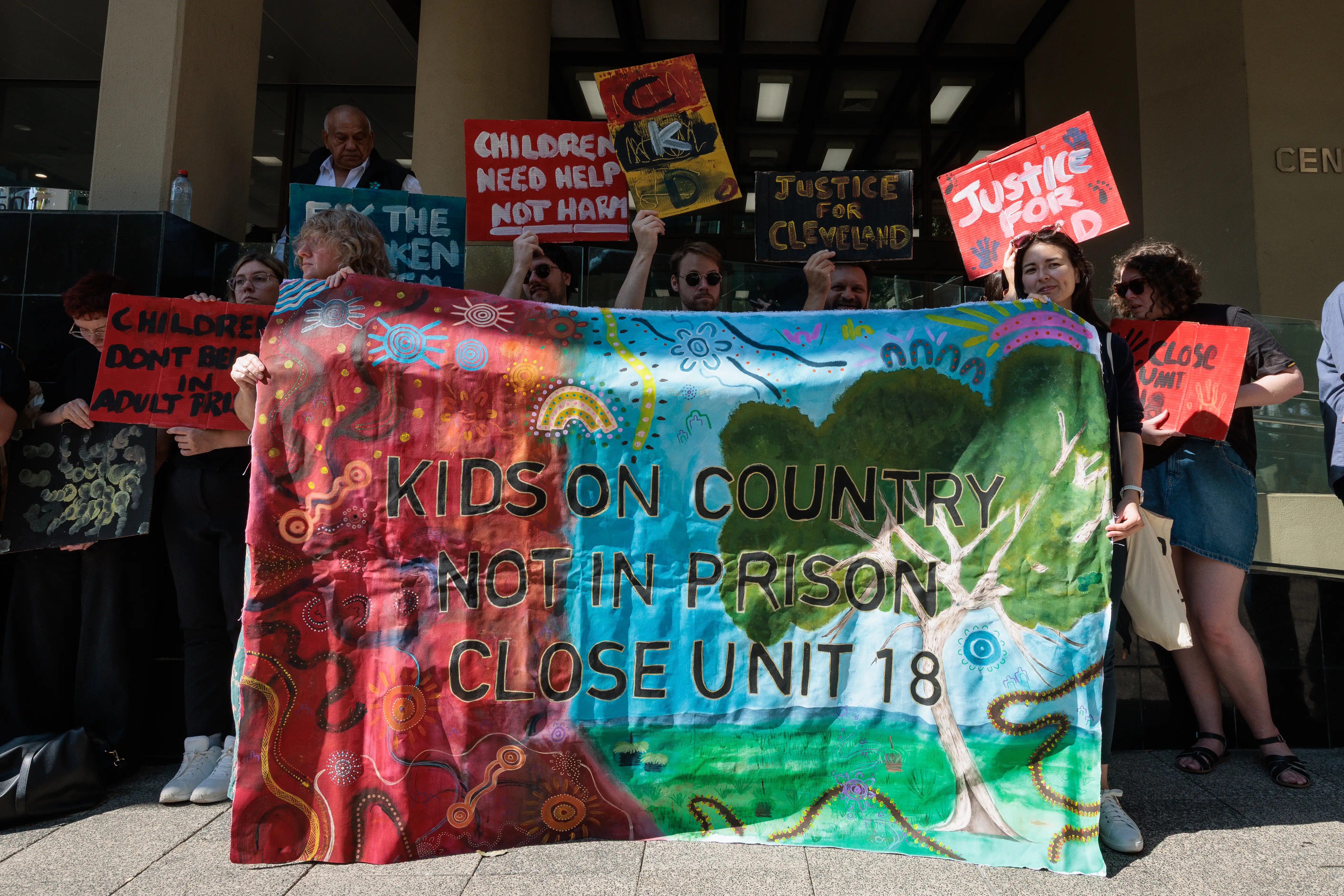 Supporters and family of Cleveland Dodd hold signs calling for the closure of Unit 18 in WA