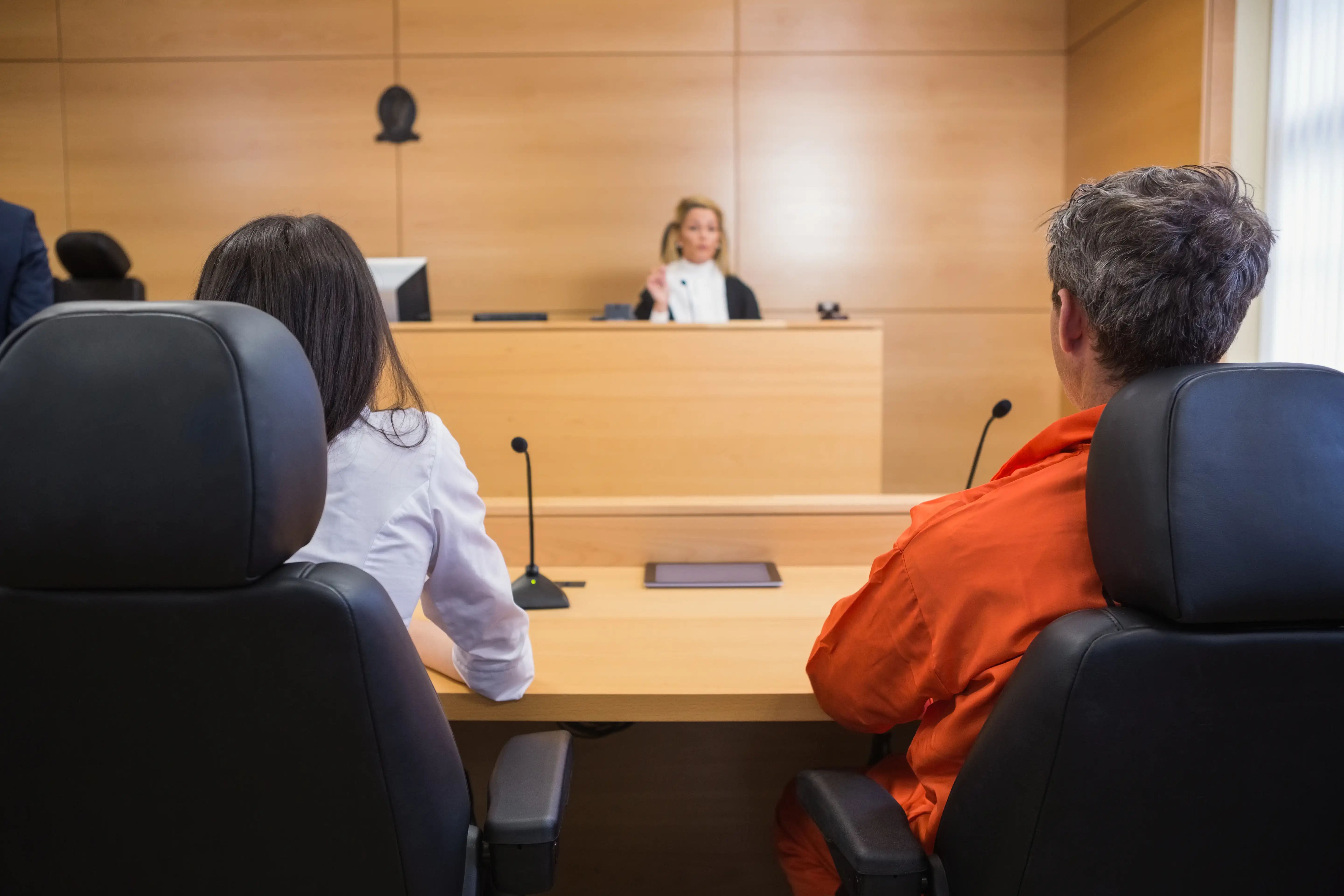 A lawyer and client listening to judge in the court room