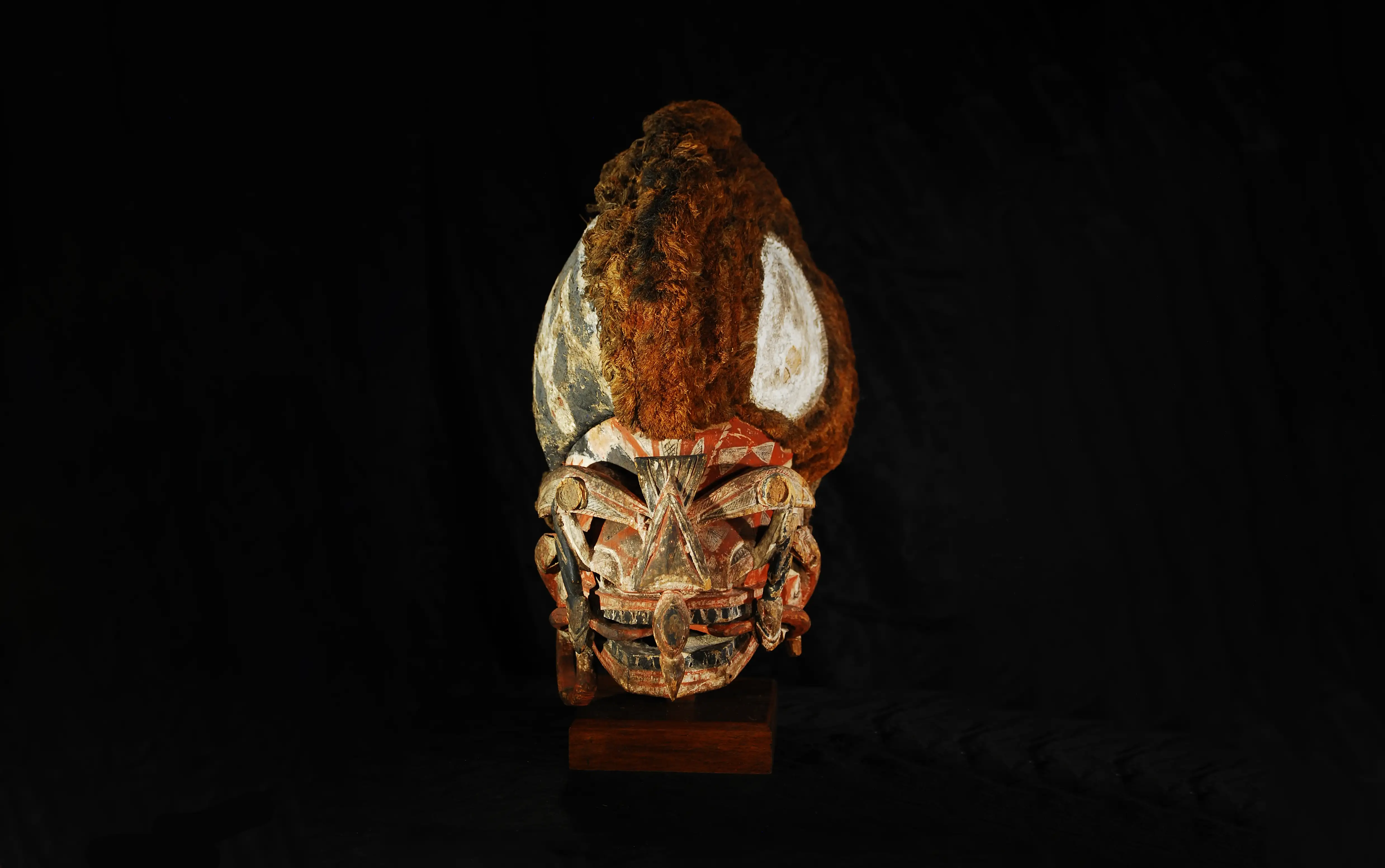 A Malagan mask against a black background