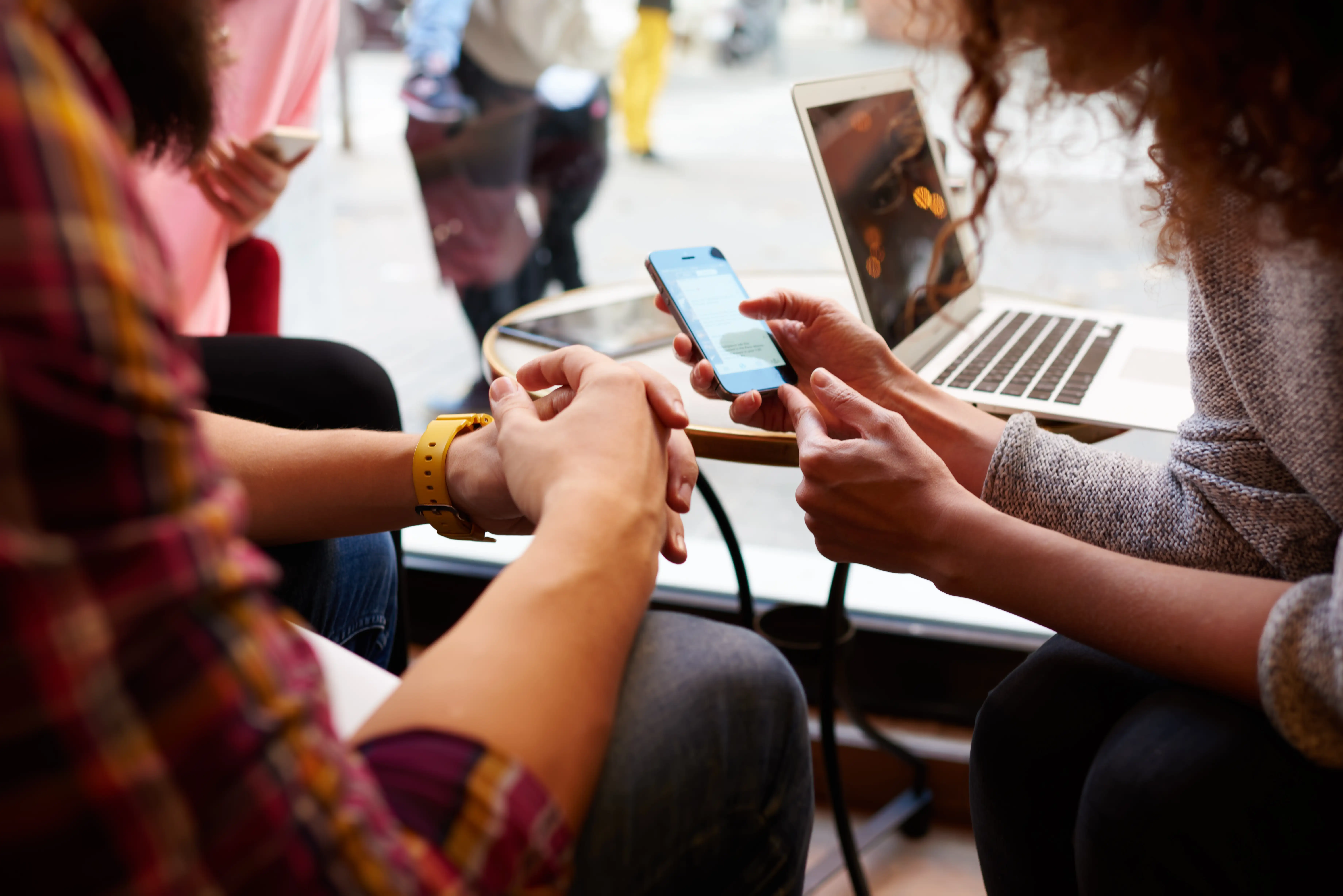 People looking at a phone in a cafe