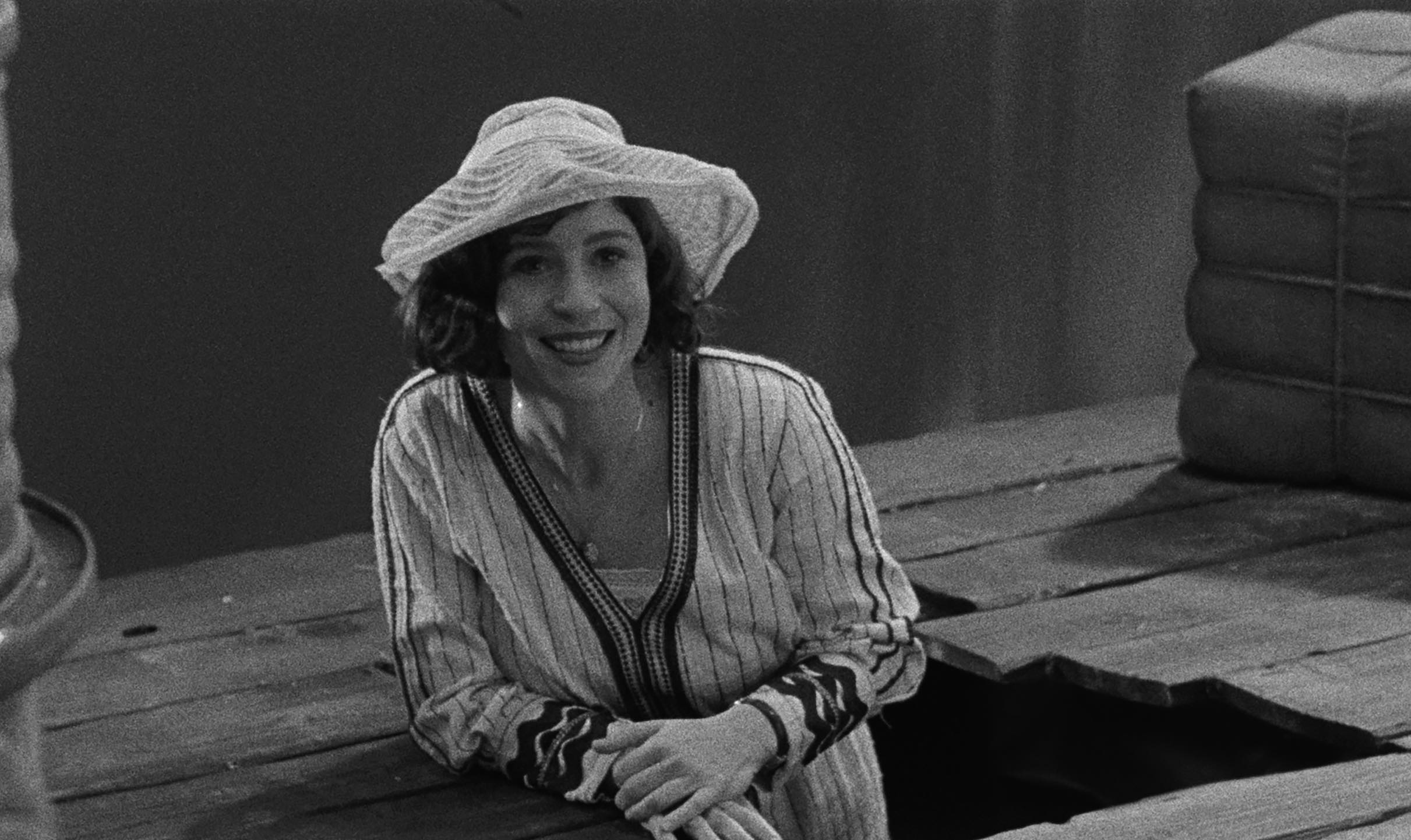 Black and white movie still of a smiling woman