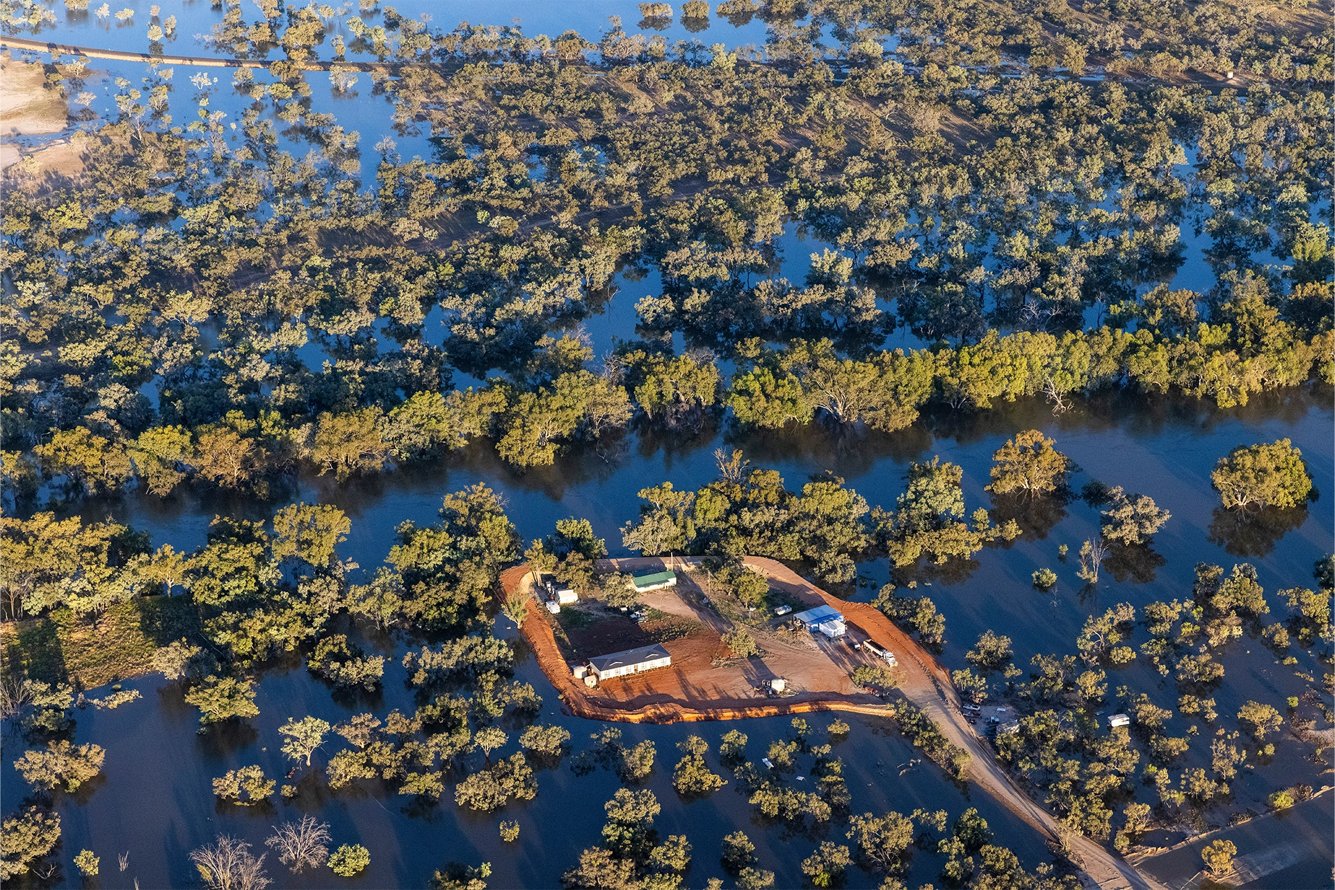 Overhead shot of a rural property surrounded by flood waters