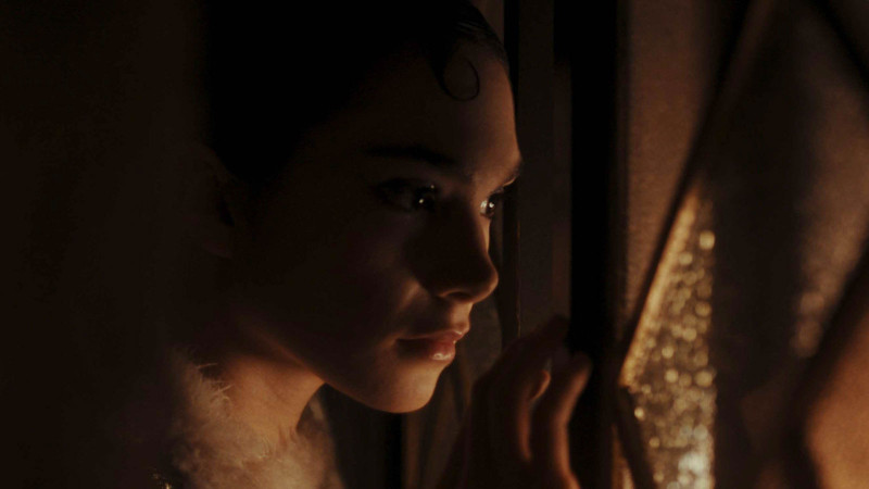 Young woman peeking through a window or door