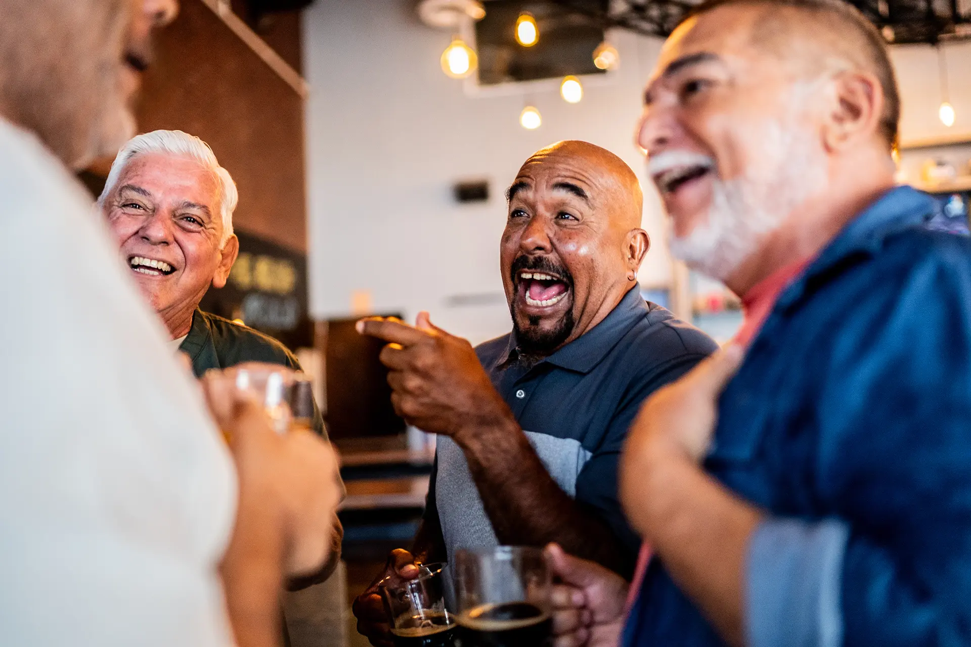 A group of senior men drinking beer and laughing in a pub