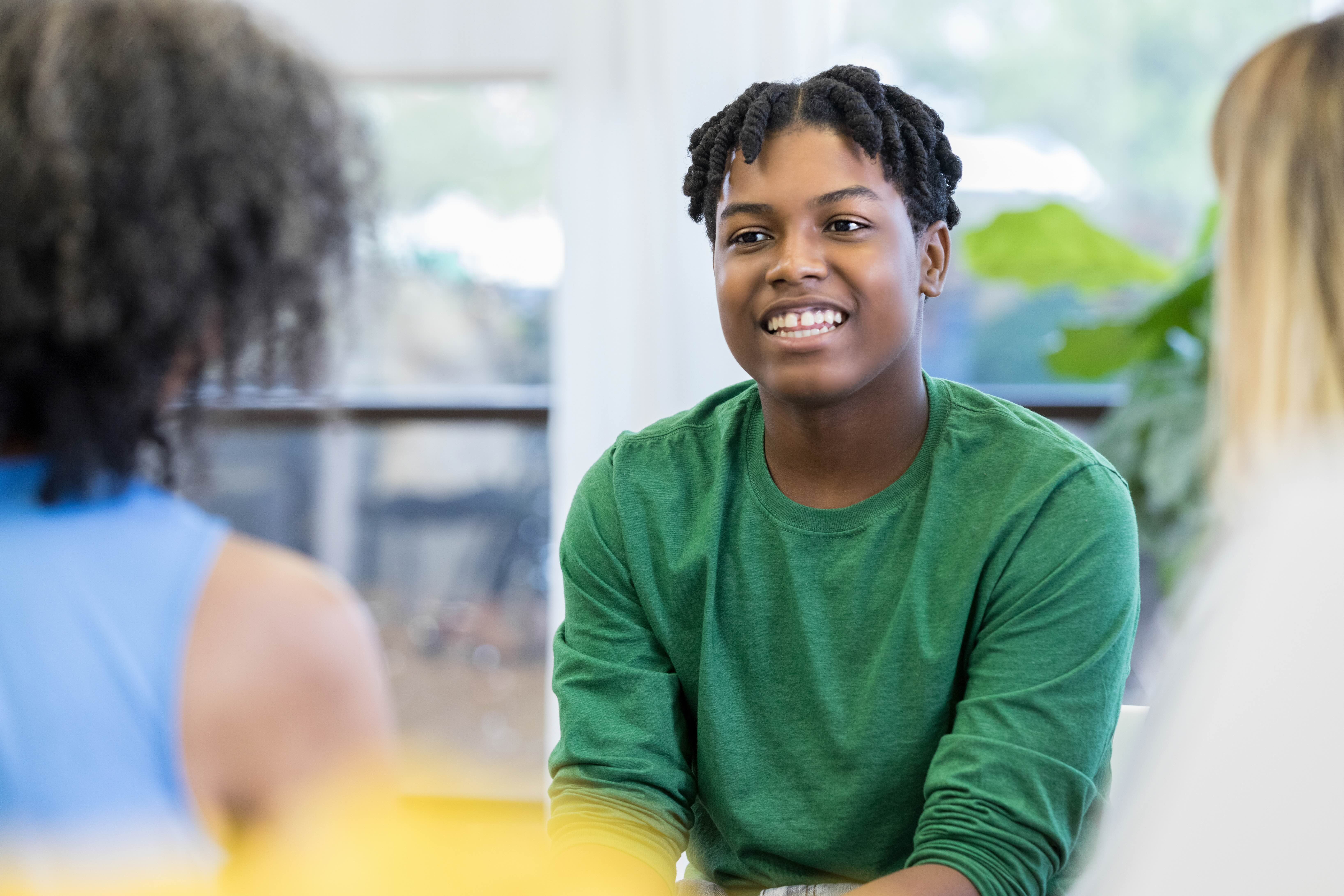 Young male talking to adults in appointment