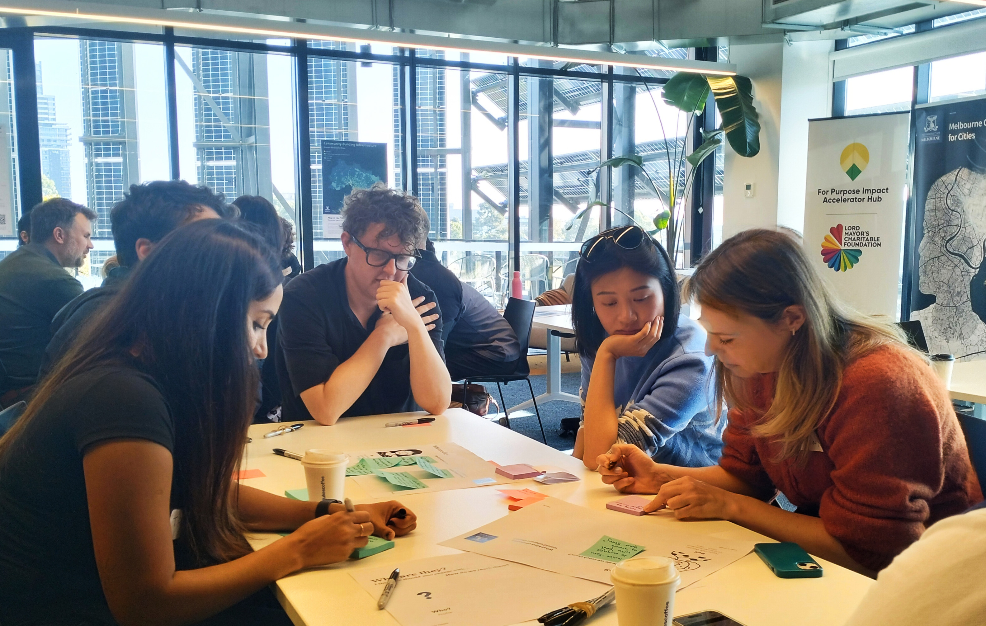 A group of people in a workshop working on a chart around a table