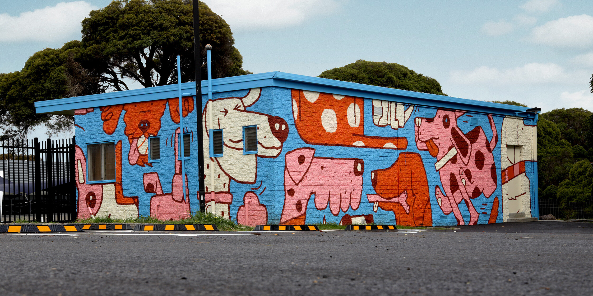 Toilet block painted with mural of dogs playing