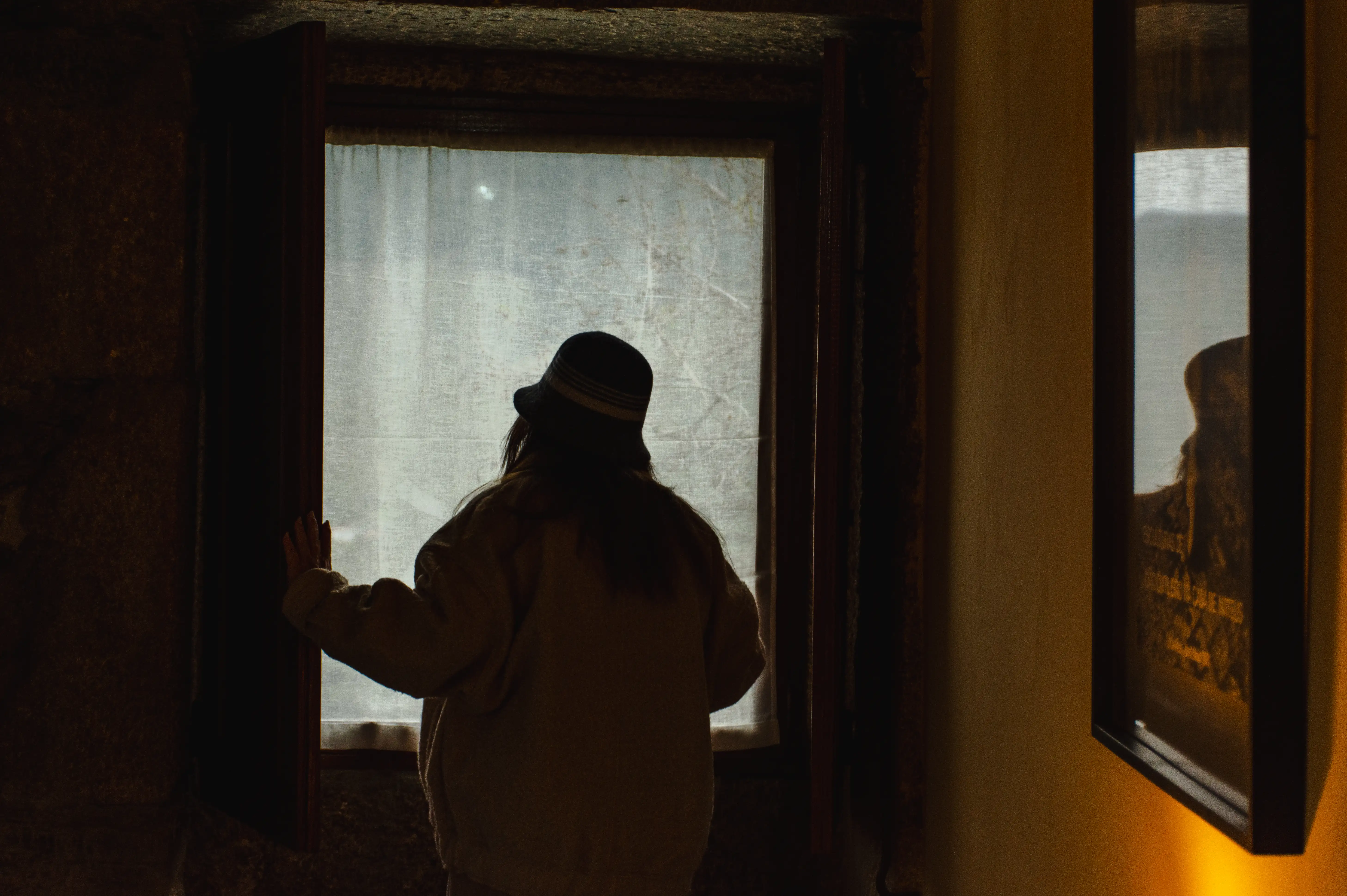 A silhouette of a woman at a window