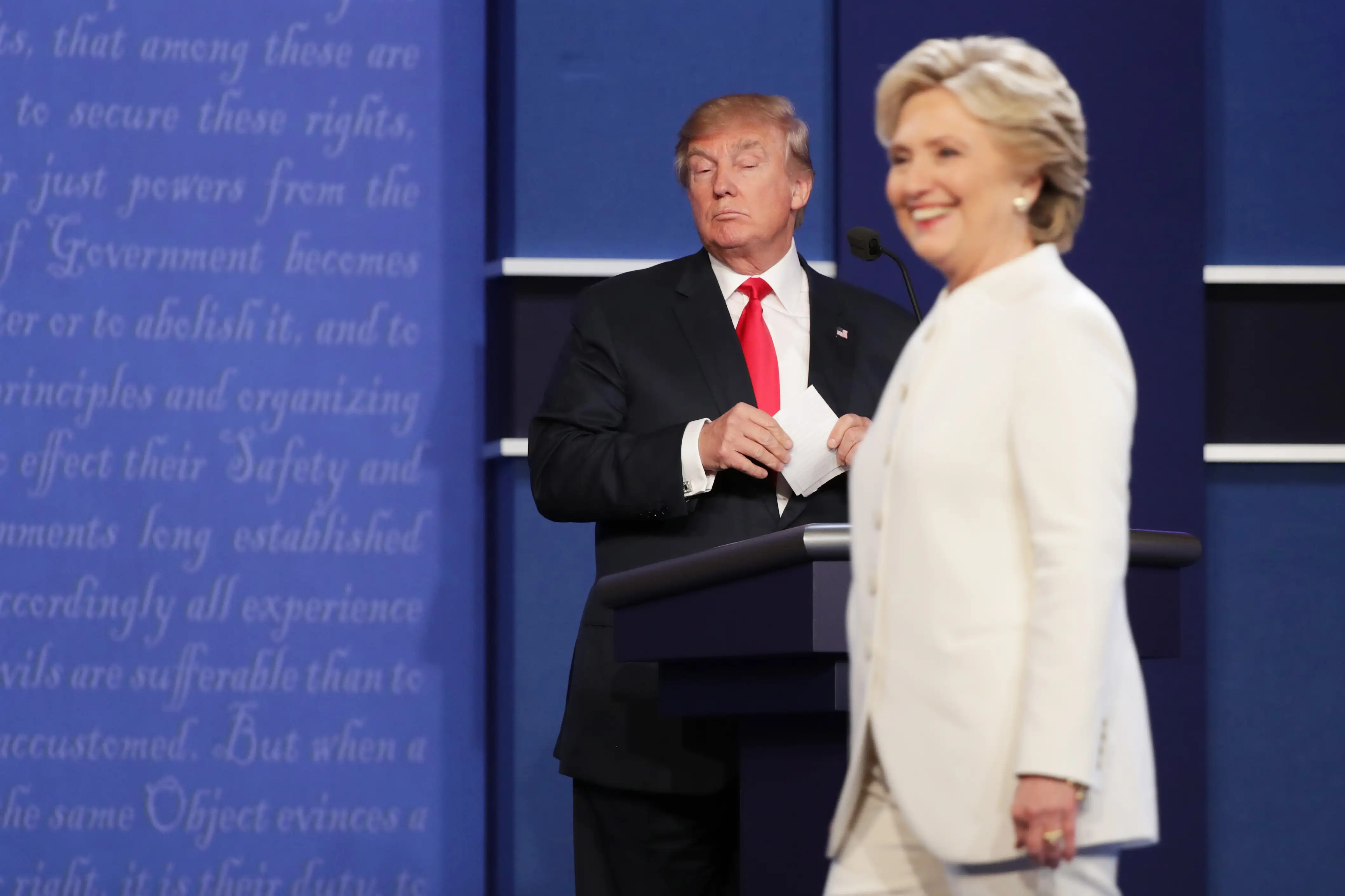 Hillary Clinton walks off stage as Republican presidential nominee Donald Trump looks on