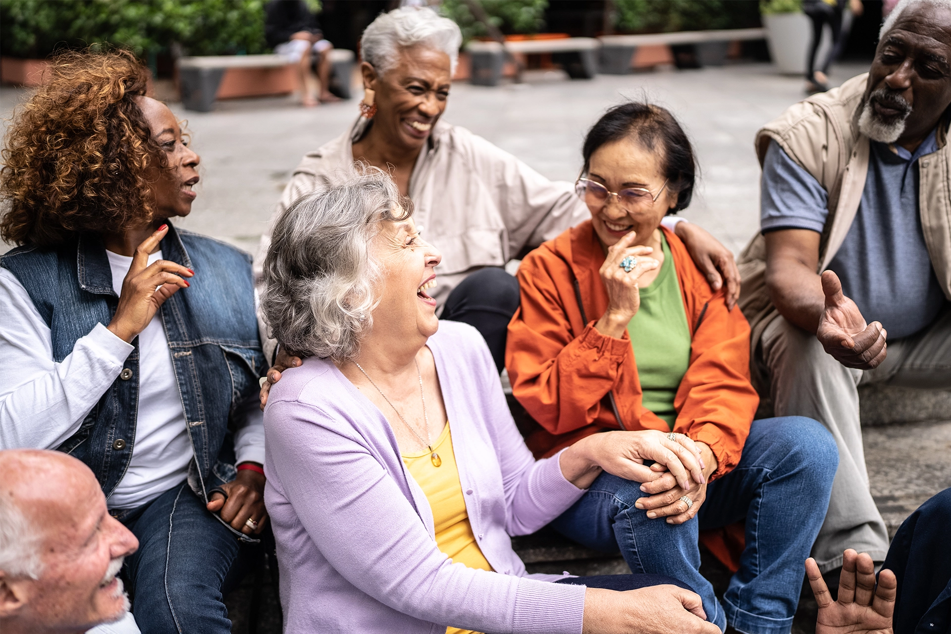 A diverse group of senior adults sitting and talking outdoors