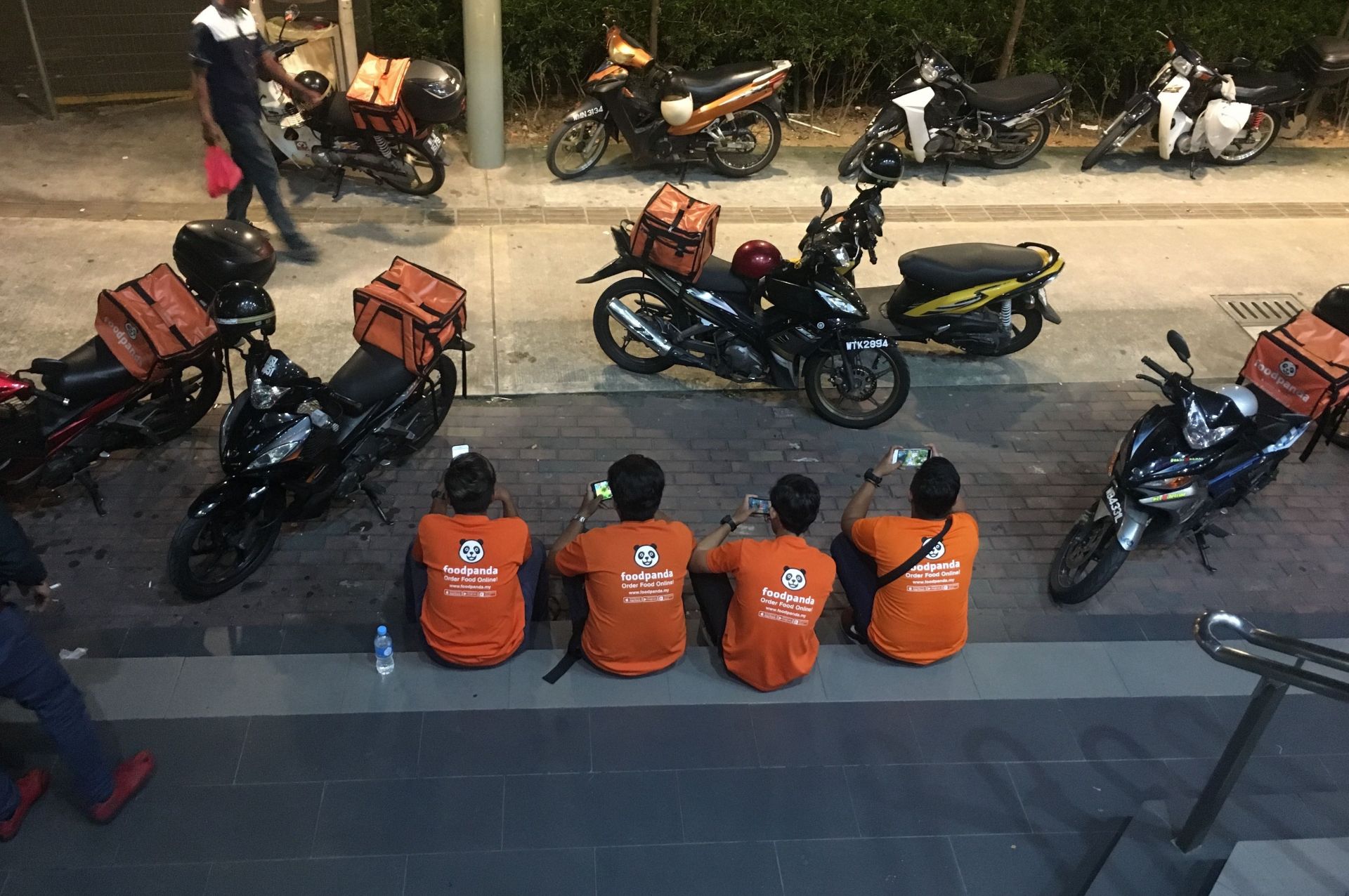 Four FoodPanda workers on their phones