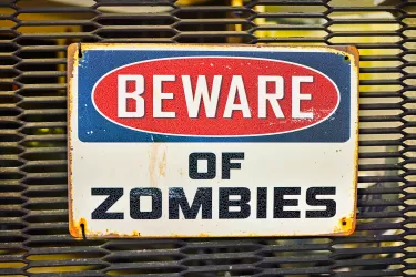 Beware of zombies sign on metal gate