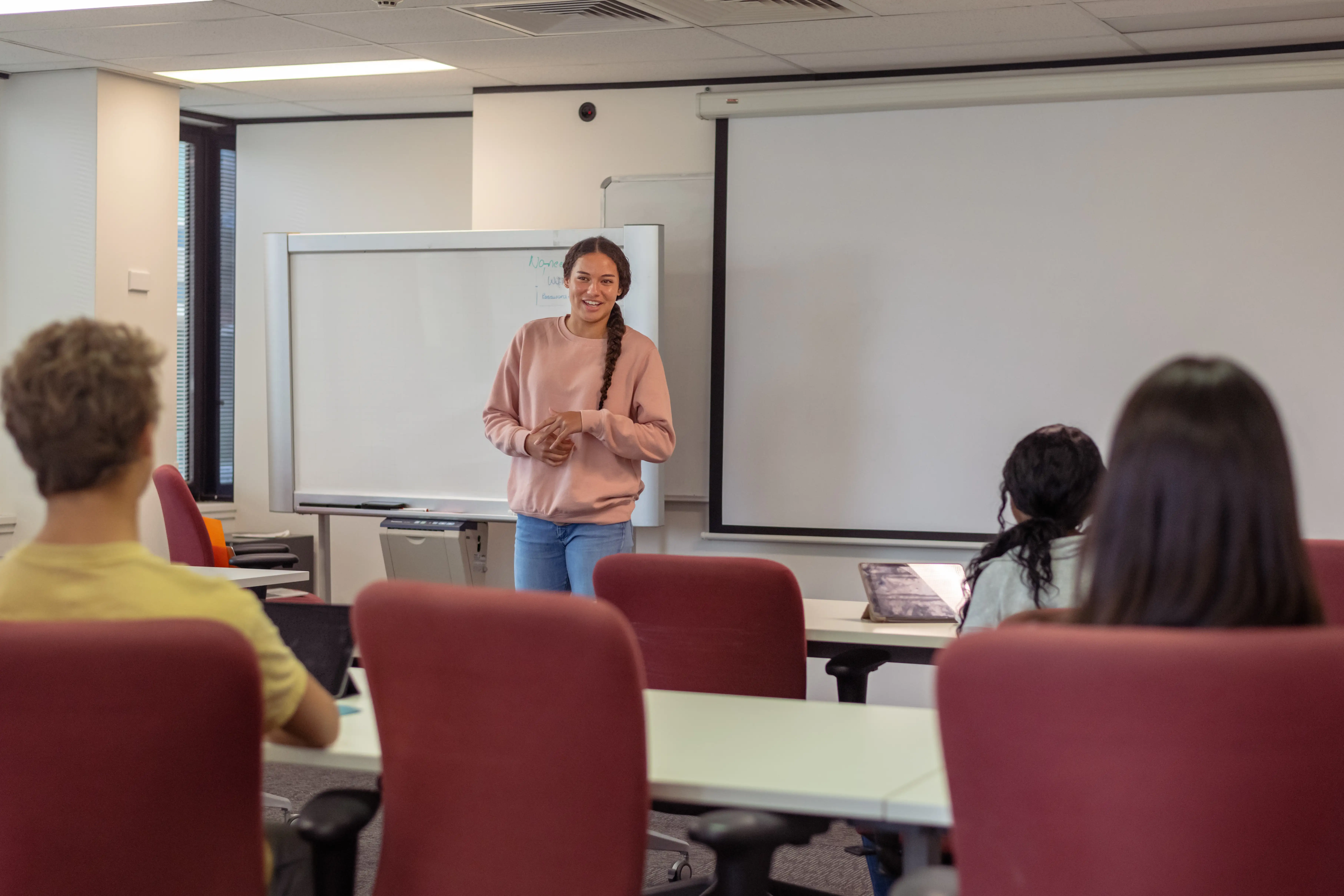 A young Indigenous women presenting to a university class.