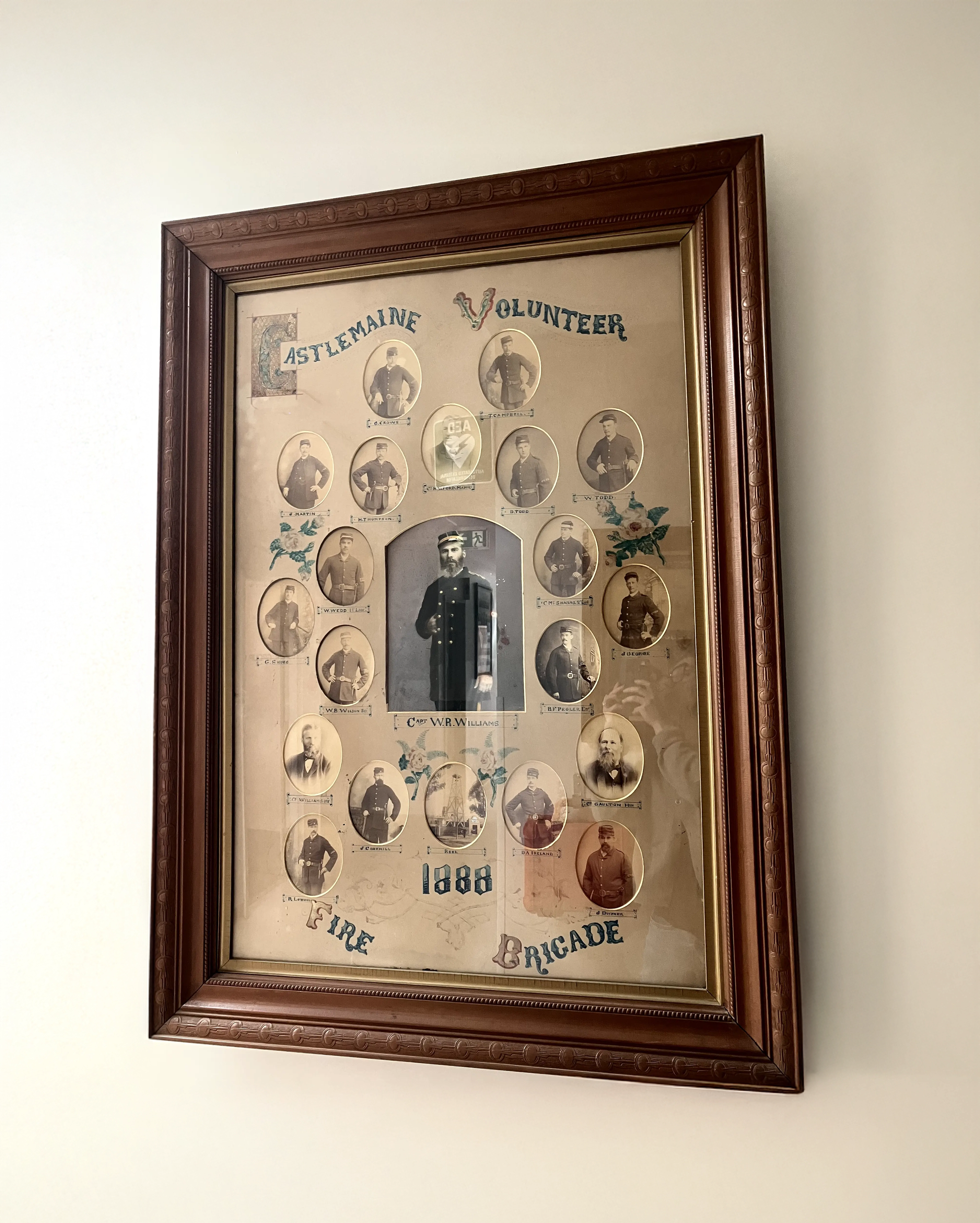 A frame containing colourless pictures of many men with the words Castlemaine Volunteer Fire Brigade 1888 in old typeface