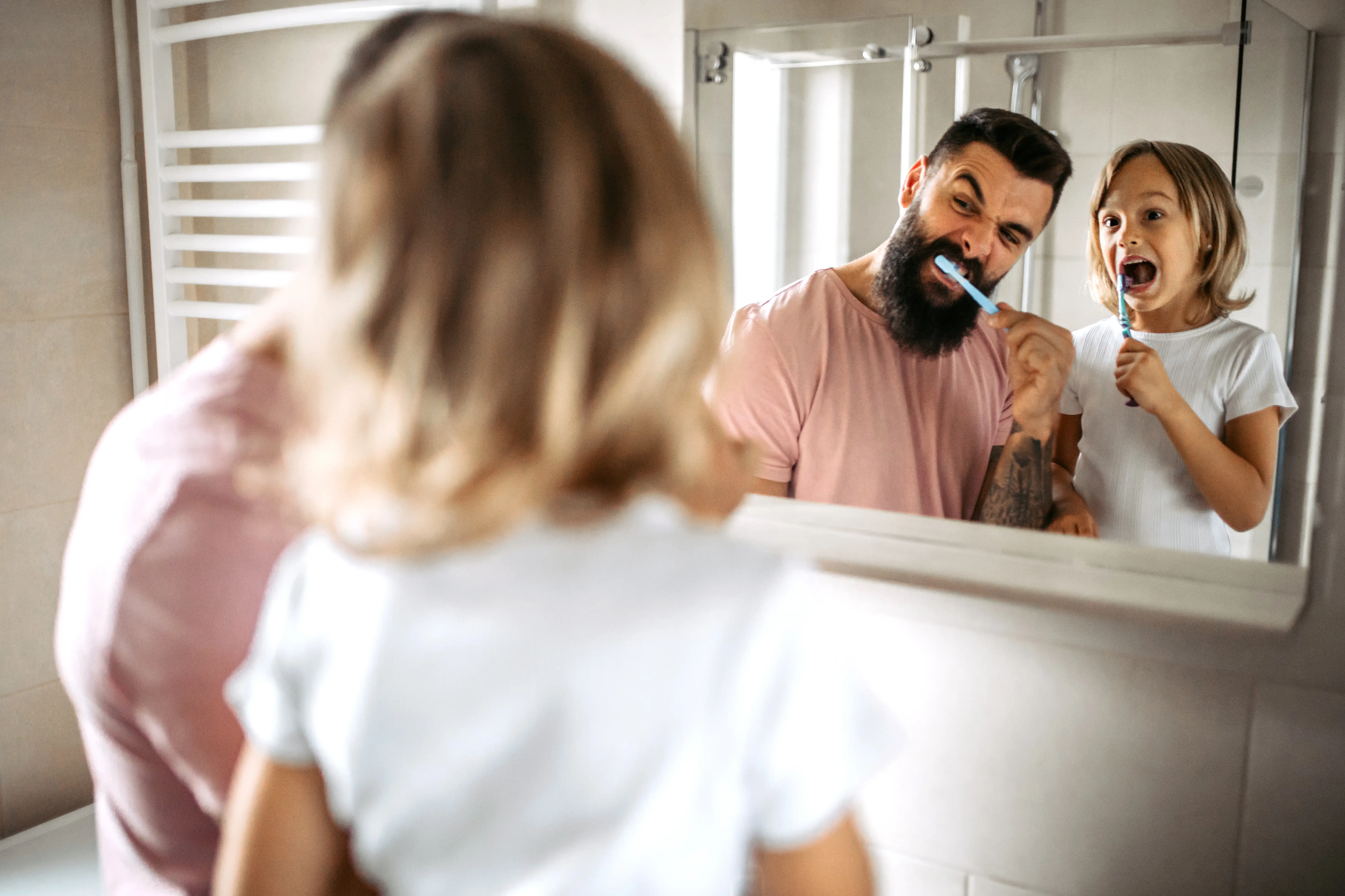 Father and daughter brushing teeth
