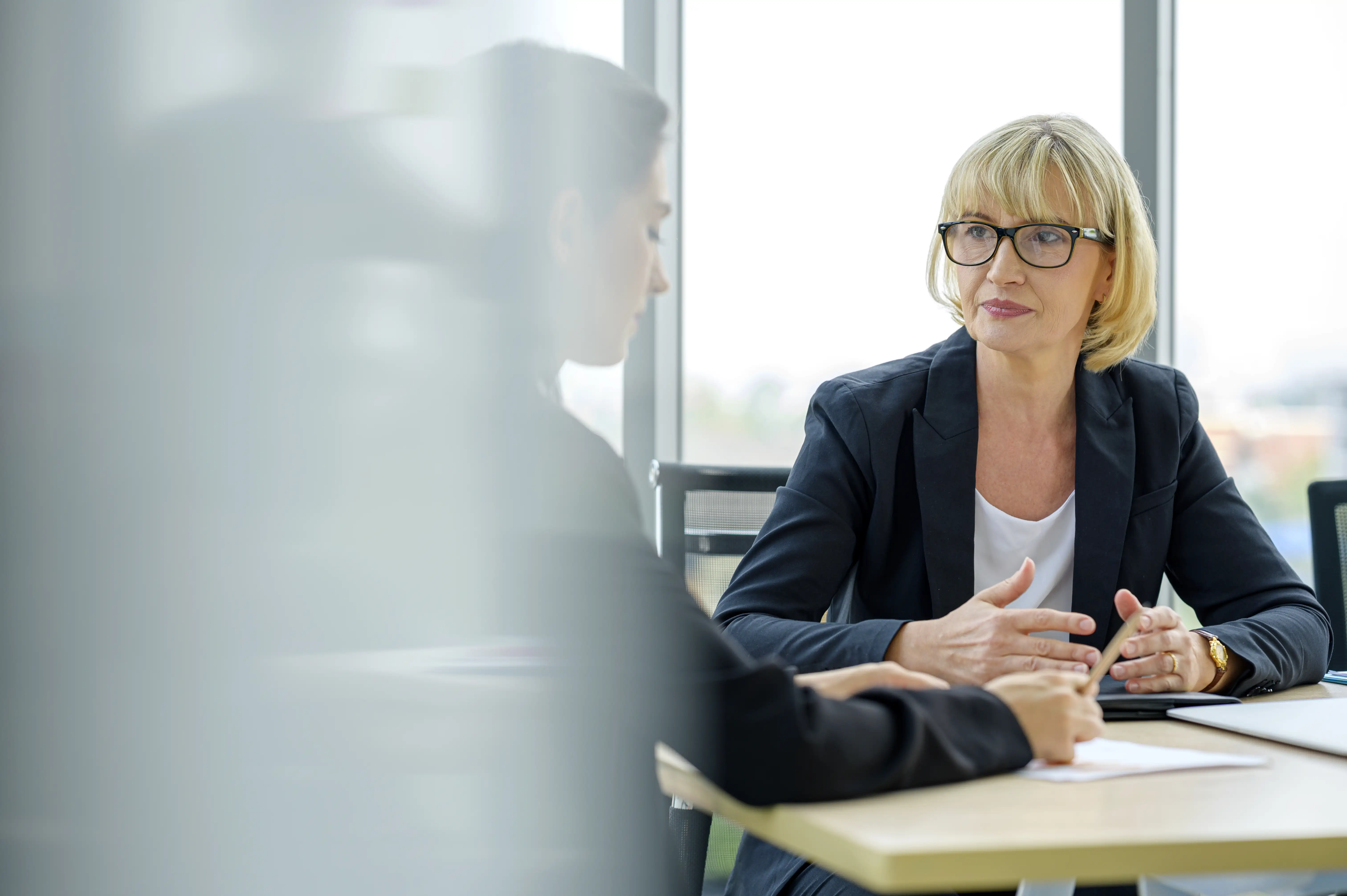 Serious female financial advisor and client discussing financial plan