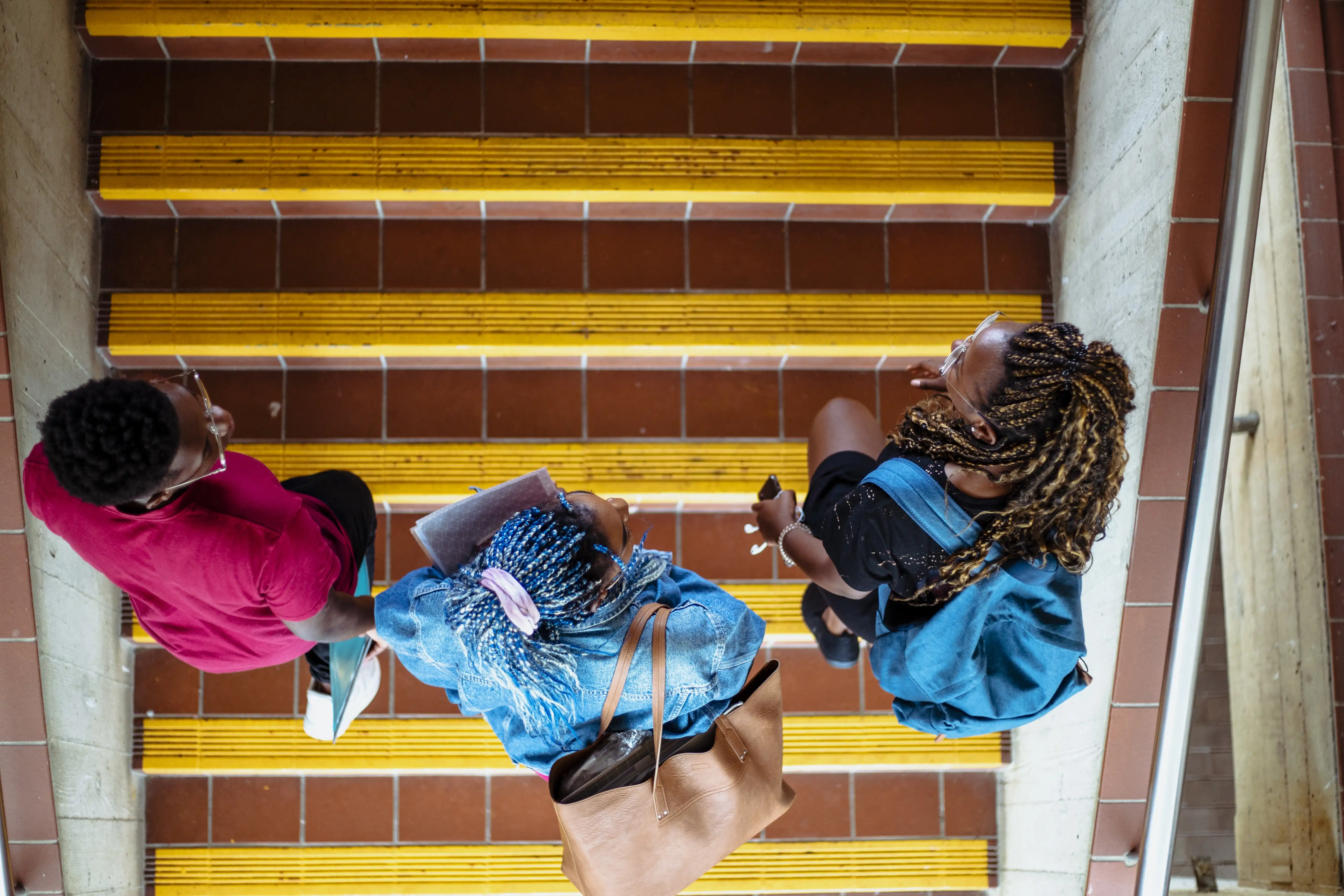 Looking down on three women as they walk up a set of steps at a campus