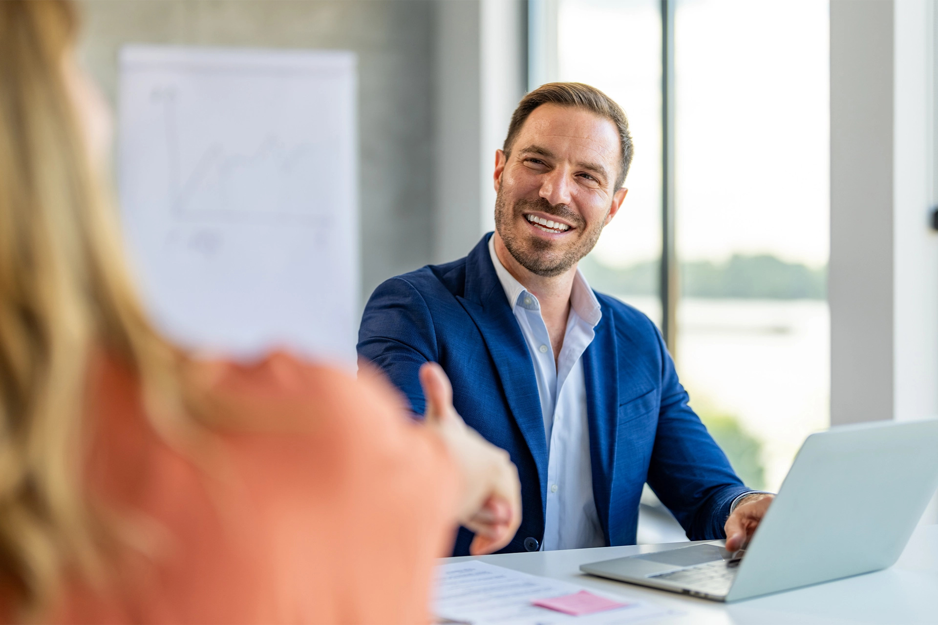 Business man at desk shaking hands with someone